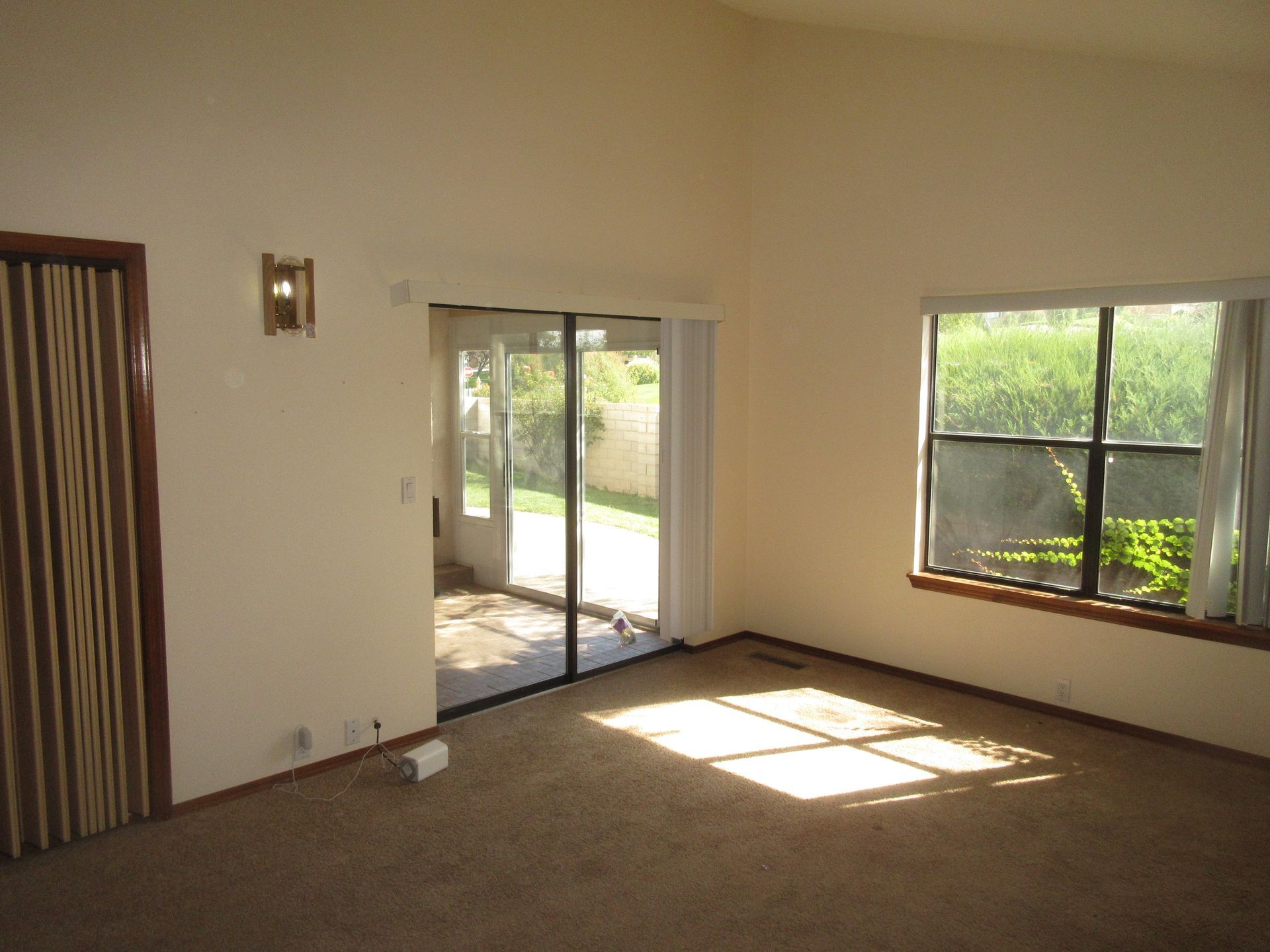 An empty living room with a sliding glass door