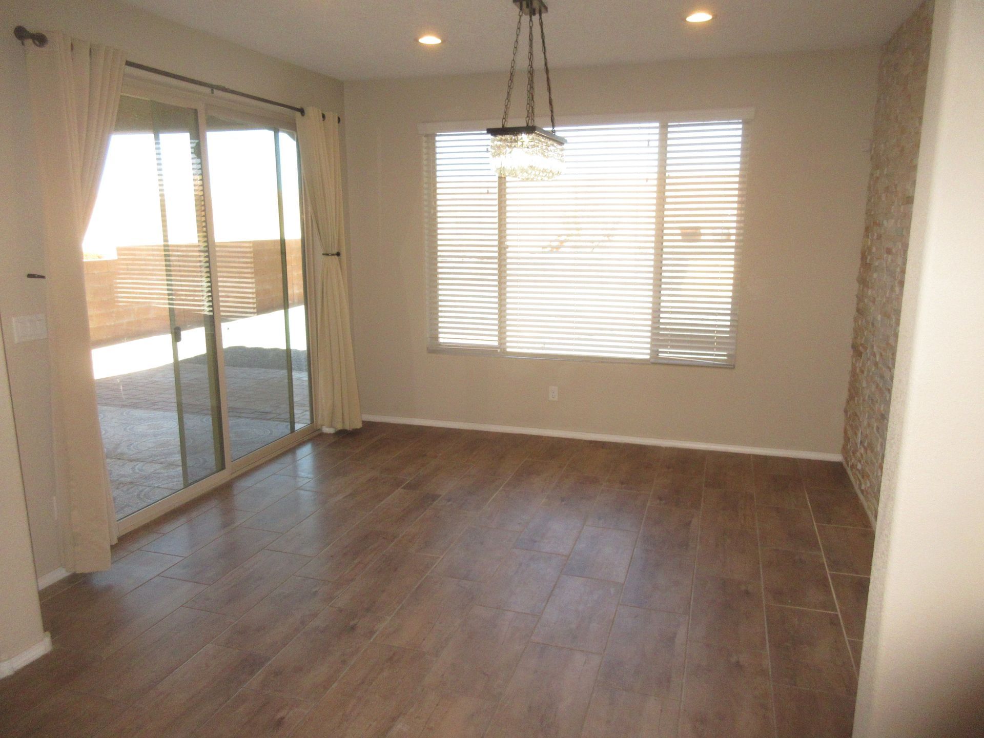 An empty living room with hardwood floors and sliding glass doors