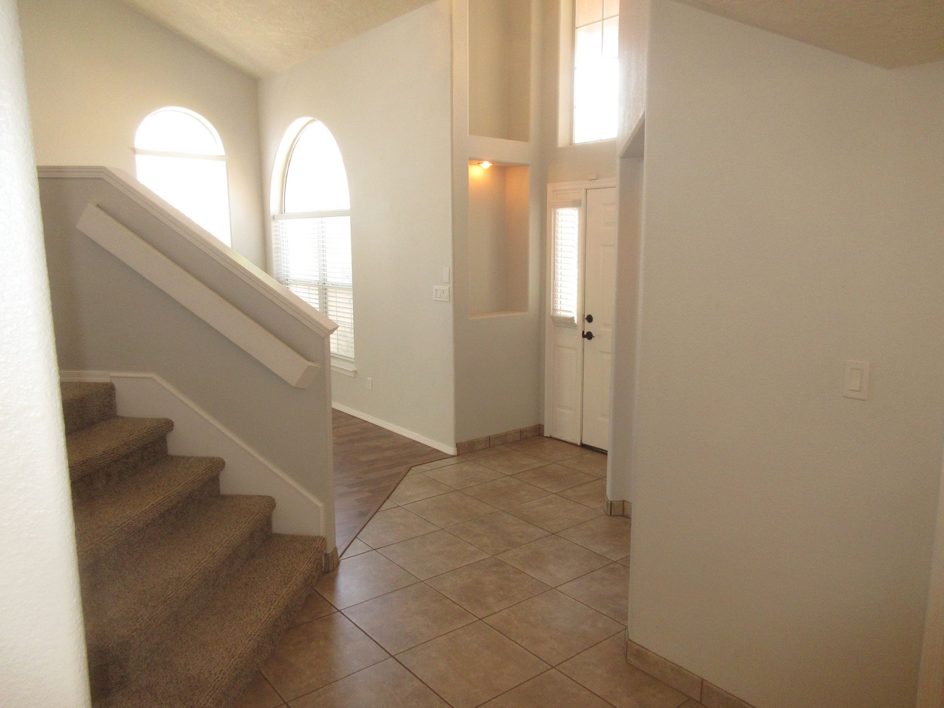 A hallway with stairs leading up to the second floor of a house.