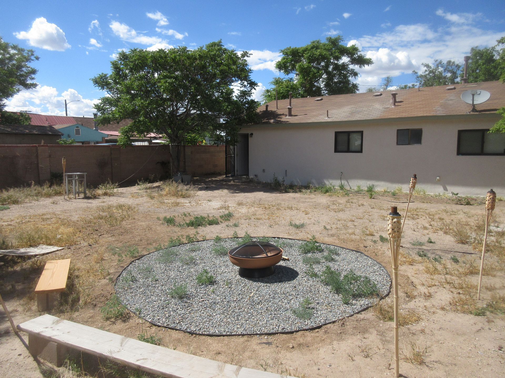 A backyard with a fire pit in the middle of it