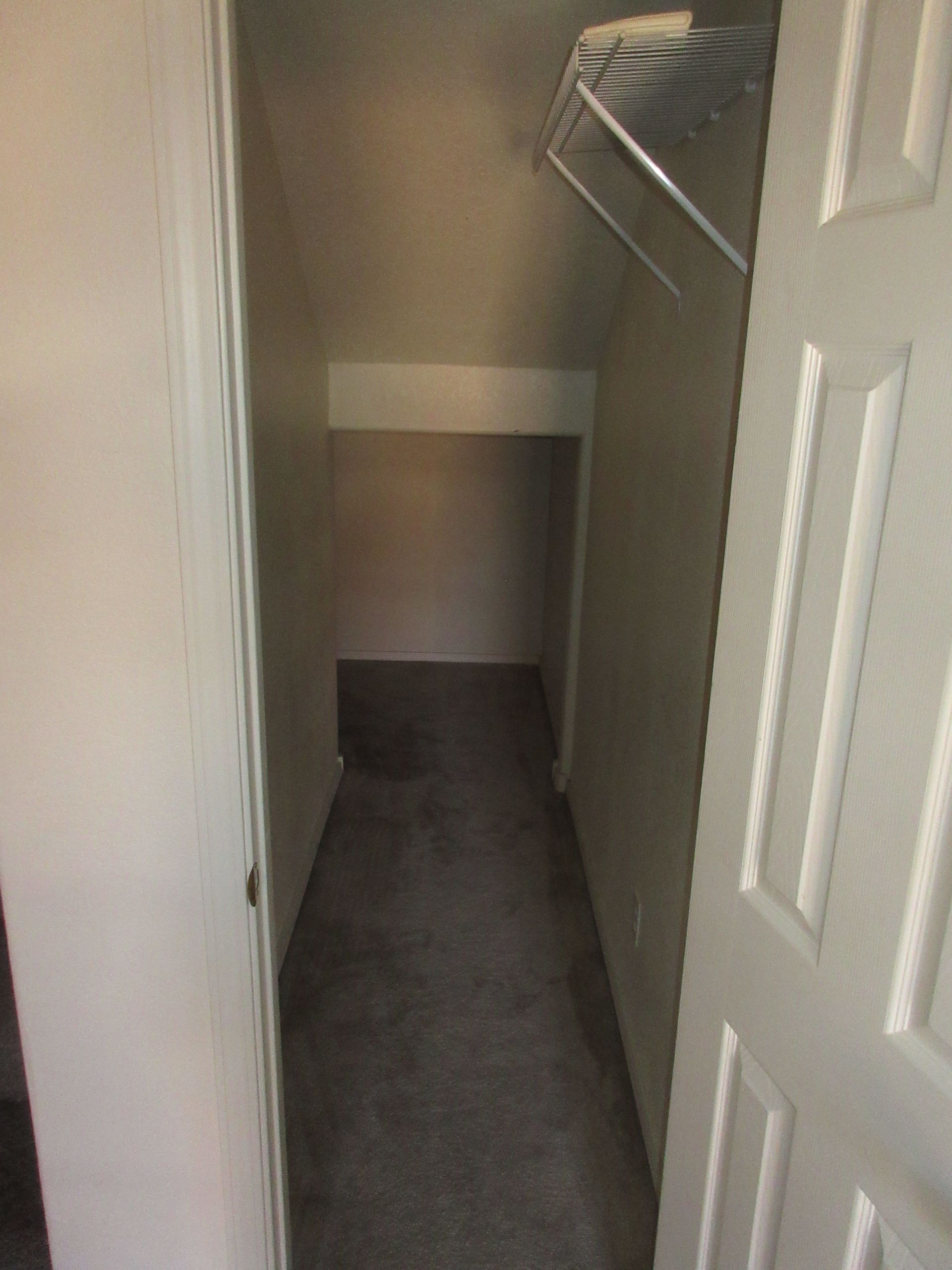 A narrow hallway with a closet in the corner