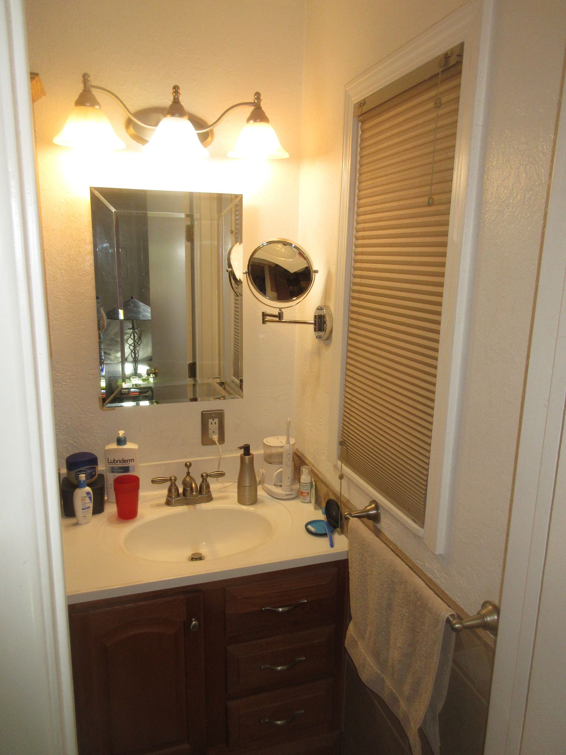 A bathroom with a sink a mirror and a window