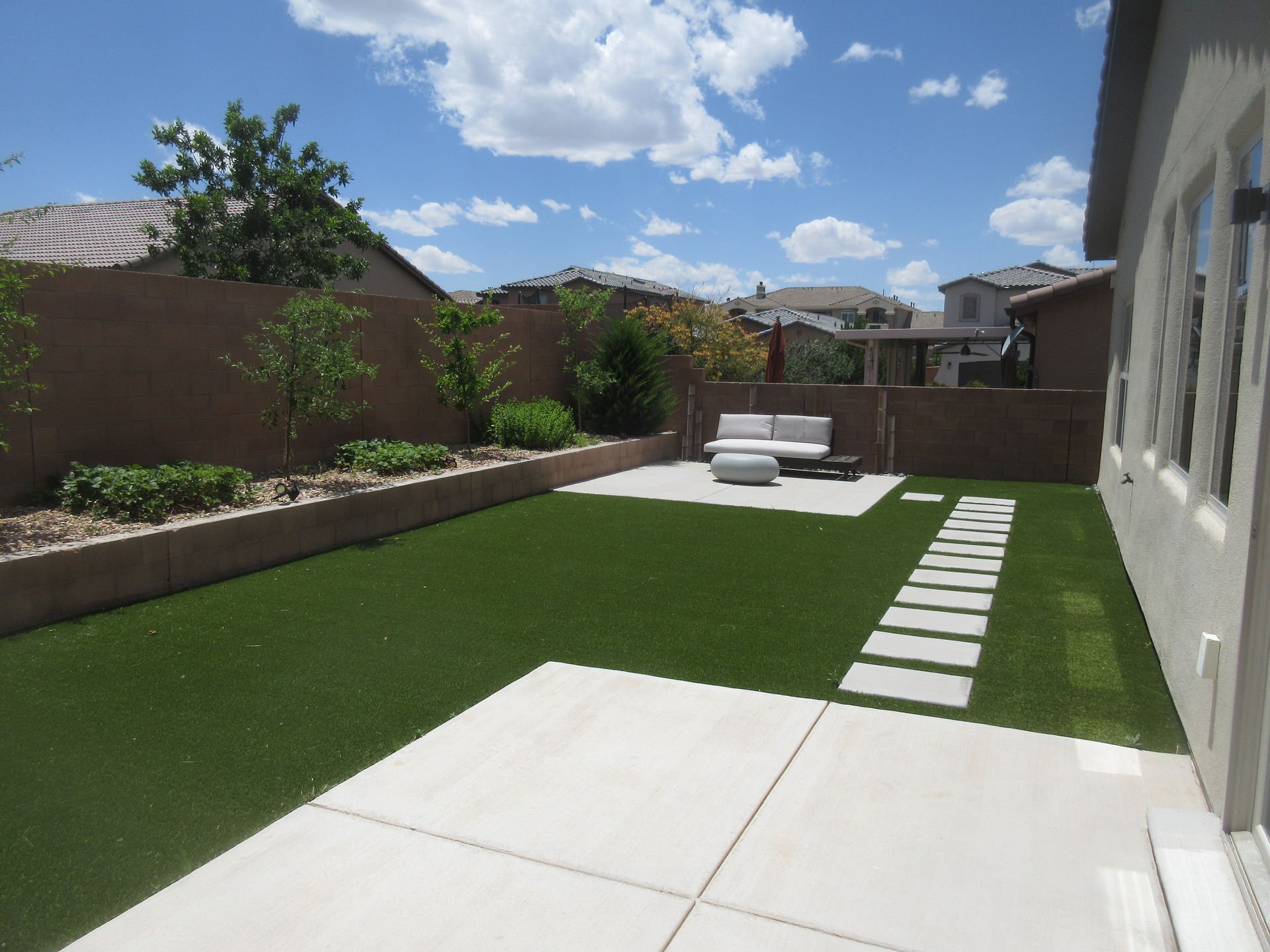 The backyard of a house with a lawn and a patio