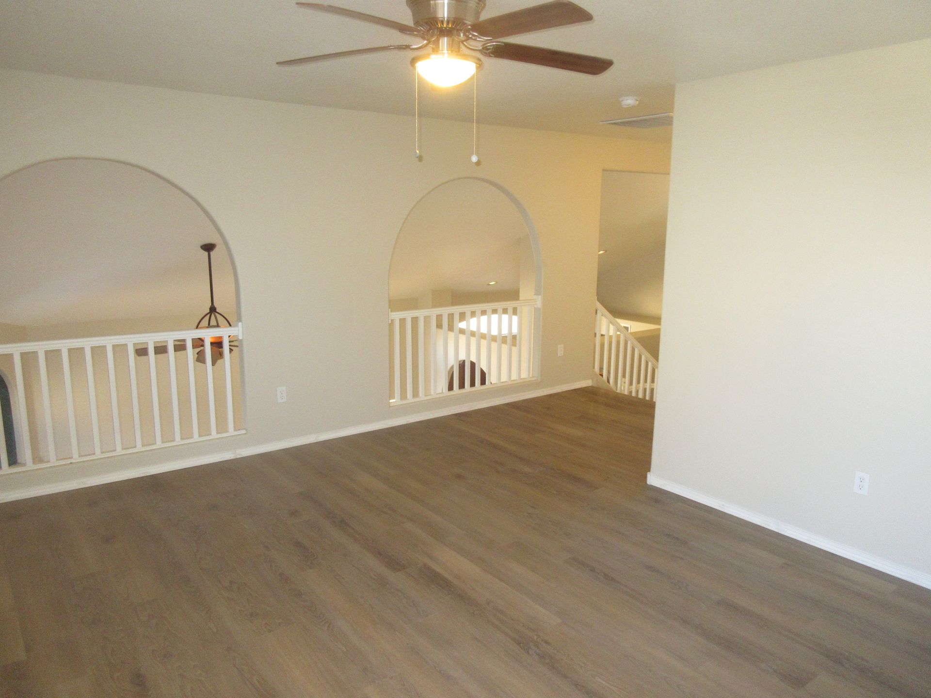 A living room with hardwood floors and a ceiling fan