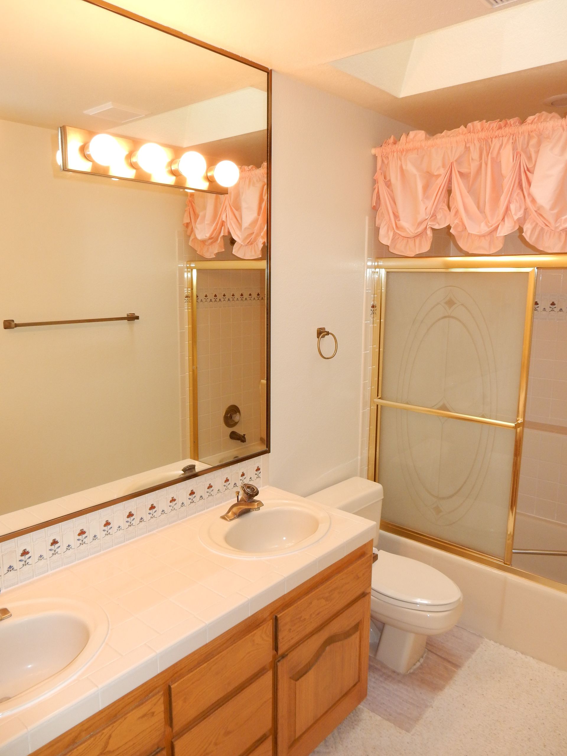 A bathroom with a toilet a sink and a mirror