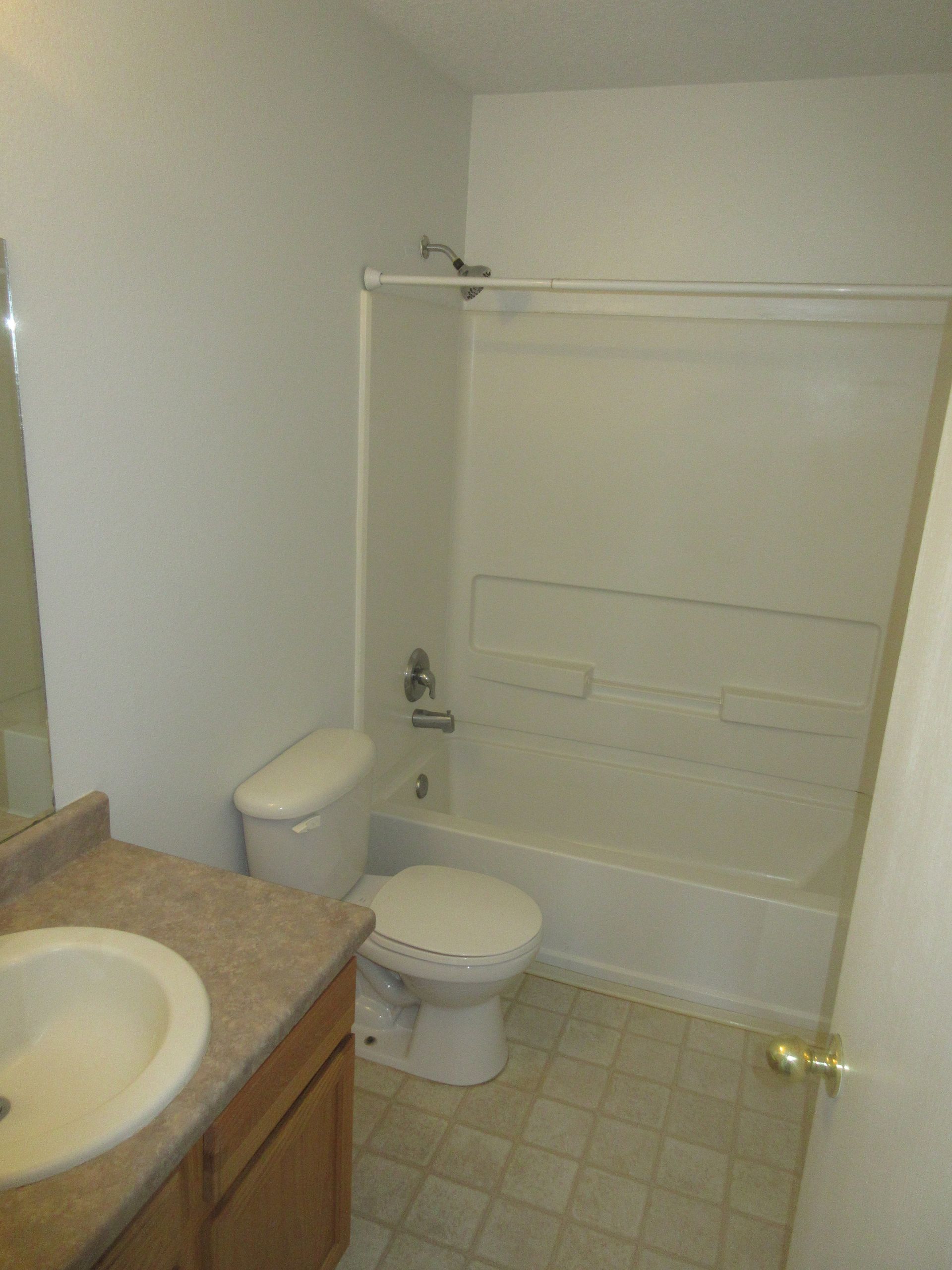 A bathroom with a toilet a sink and a bathtub