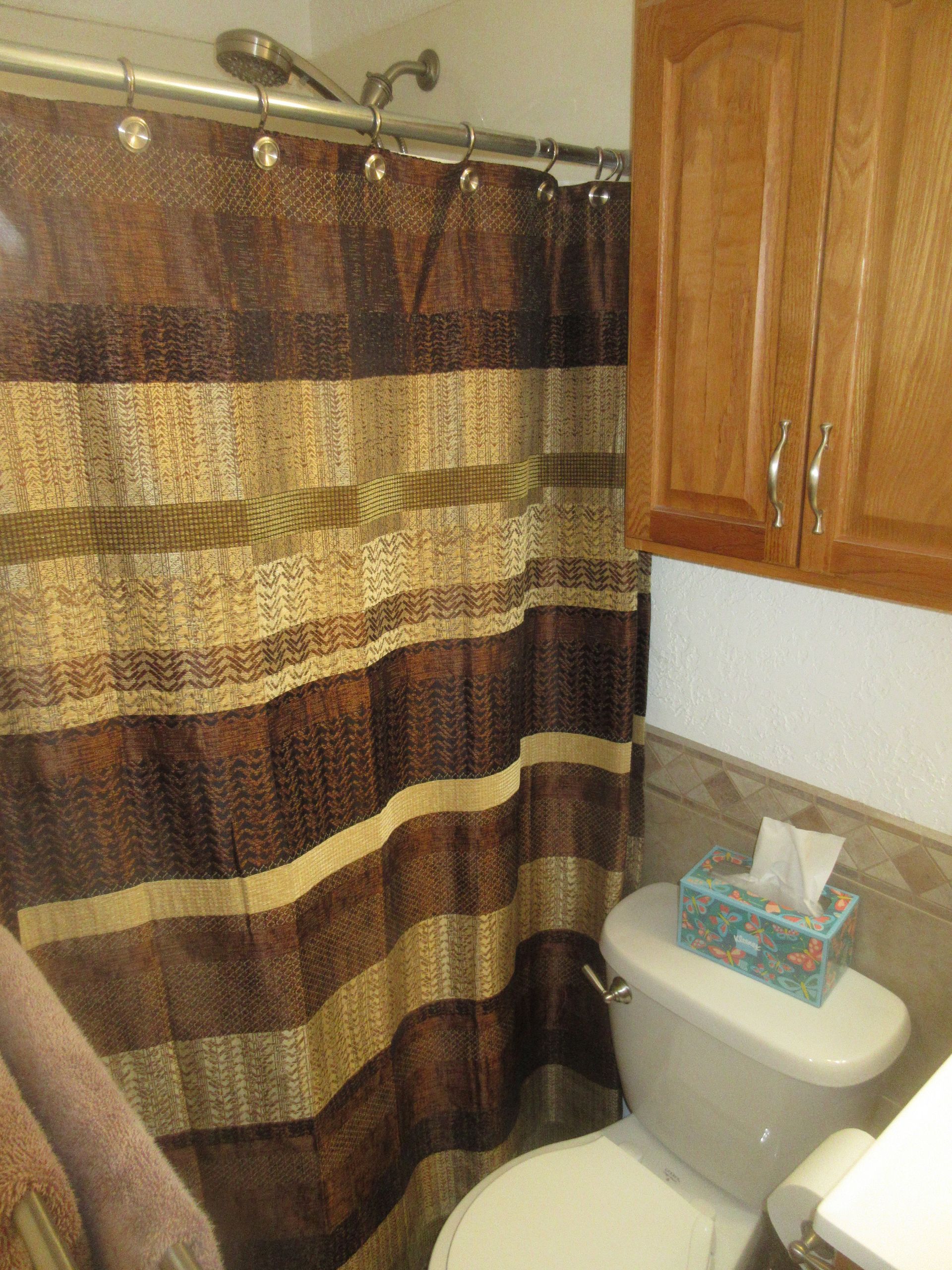 A bathroom with a toilet and a shower curtain