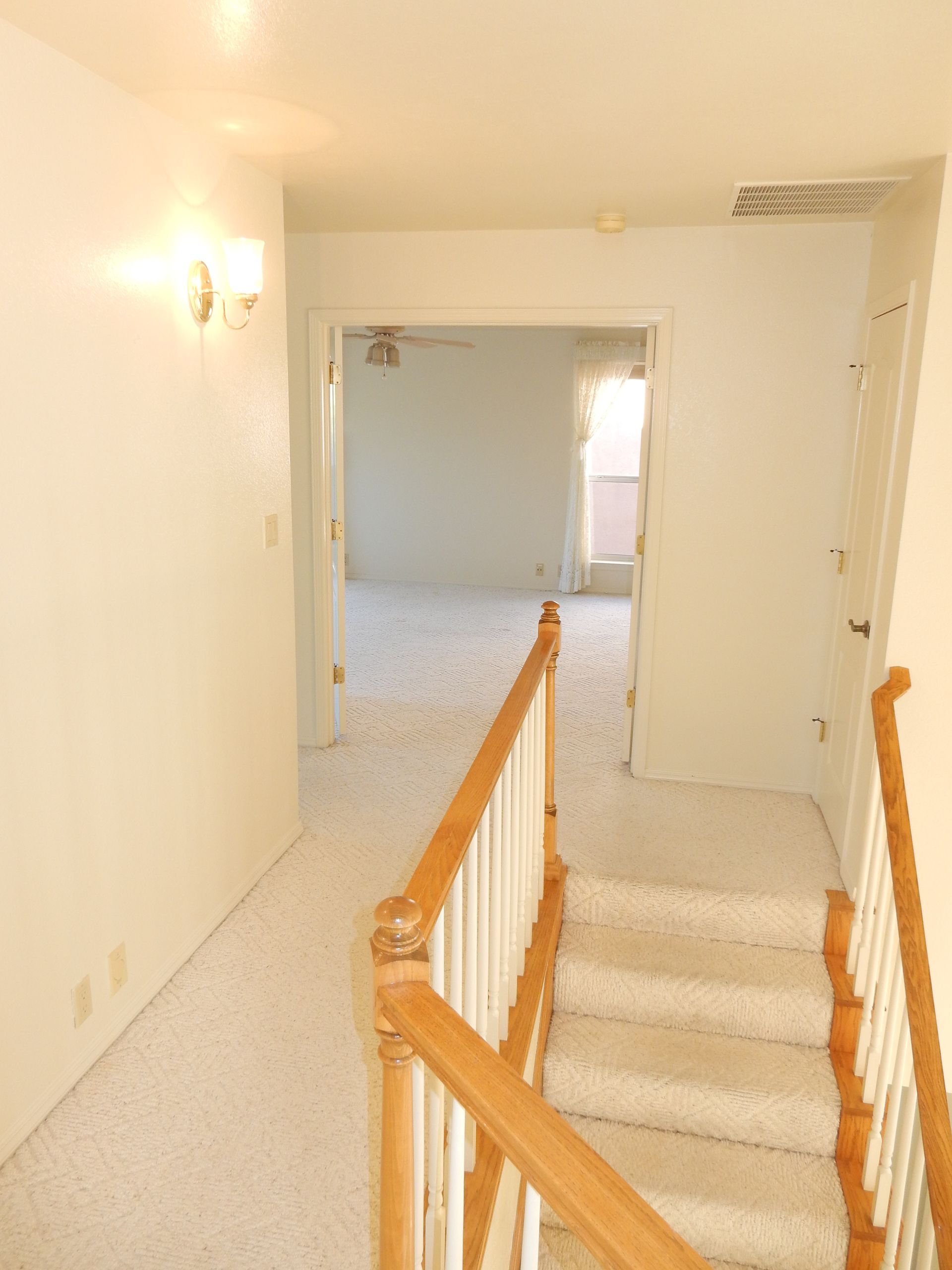A hallway with stairs leading up to a living room