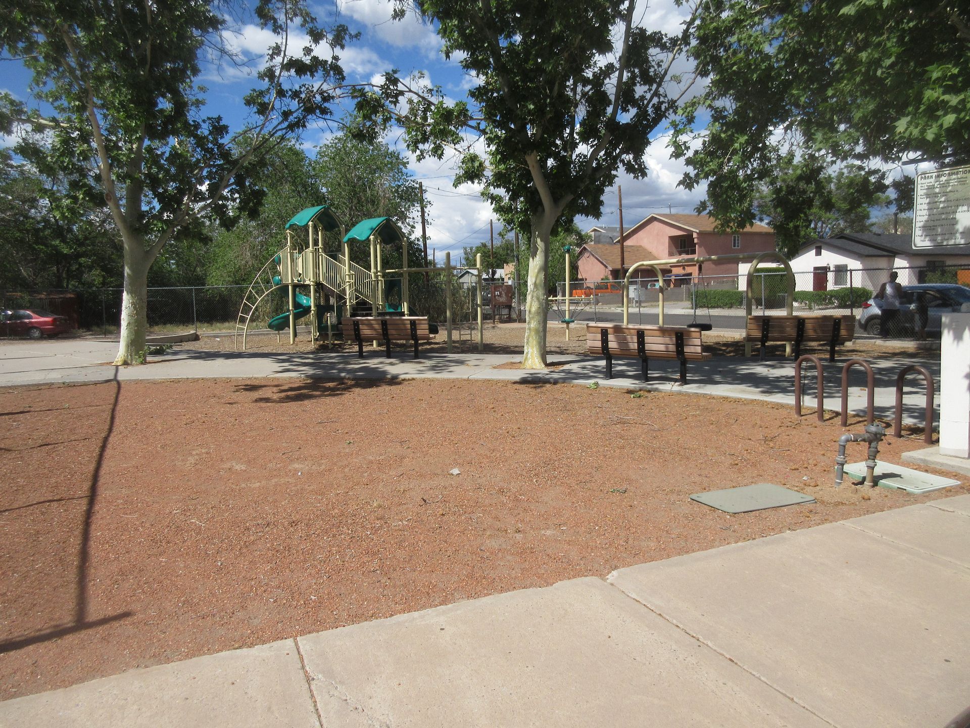 A park with a playground and benches in it