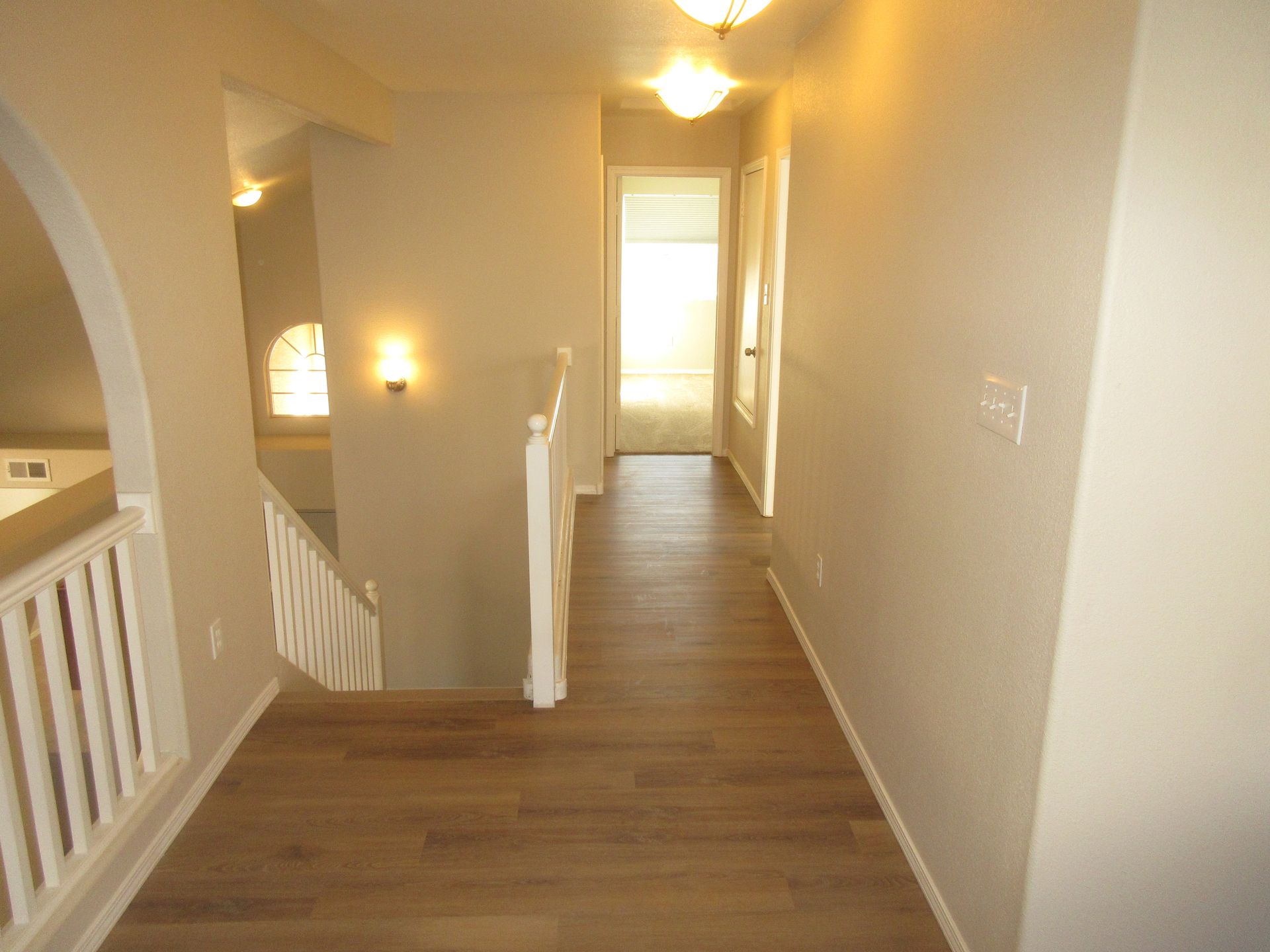 A hallway leading to a staircase in a house.