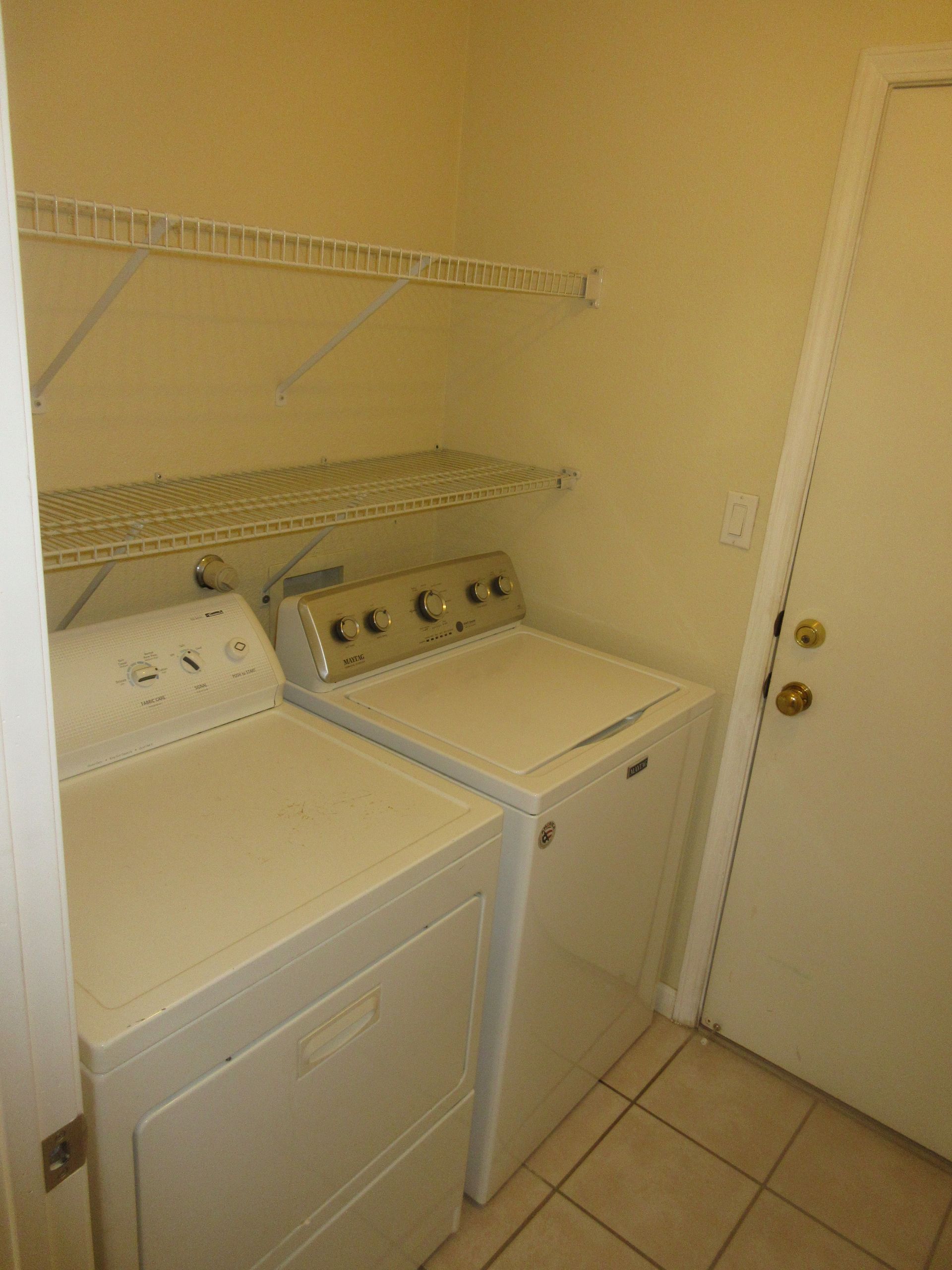 A laundry room with a washer and dryer and a door.