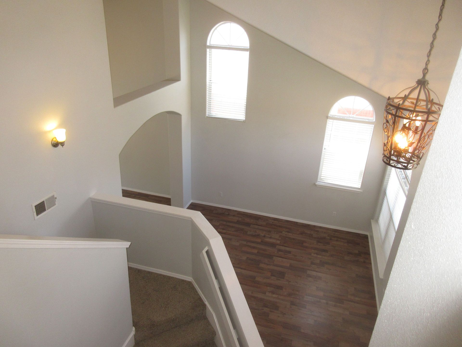 An aerial view of a staircase with a chandelier hanging from the ceiling