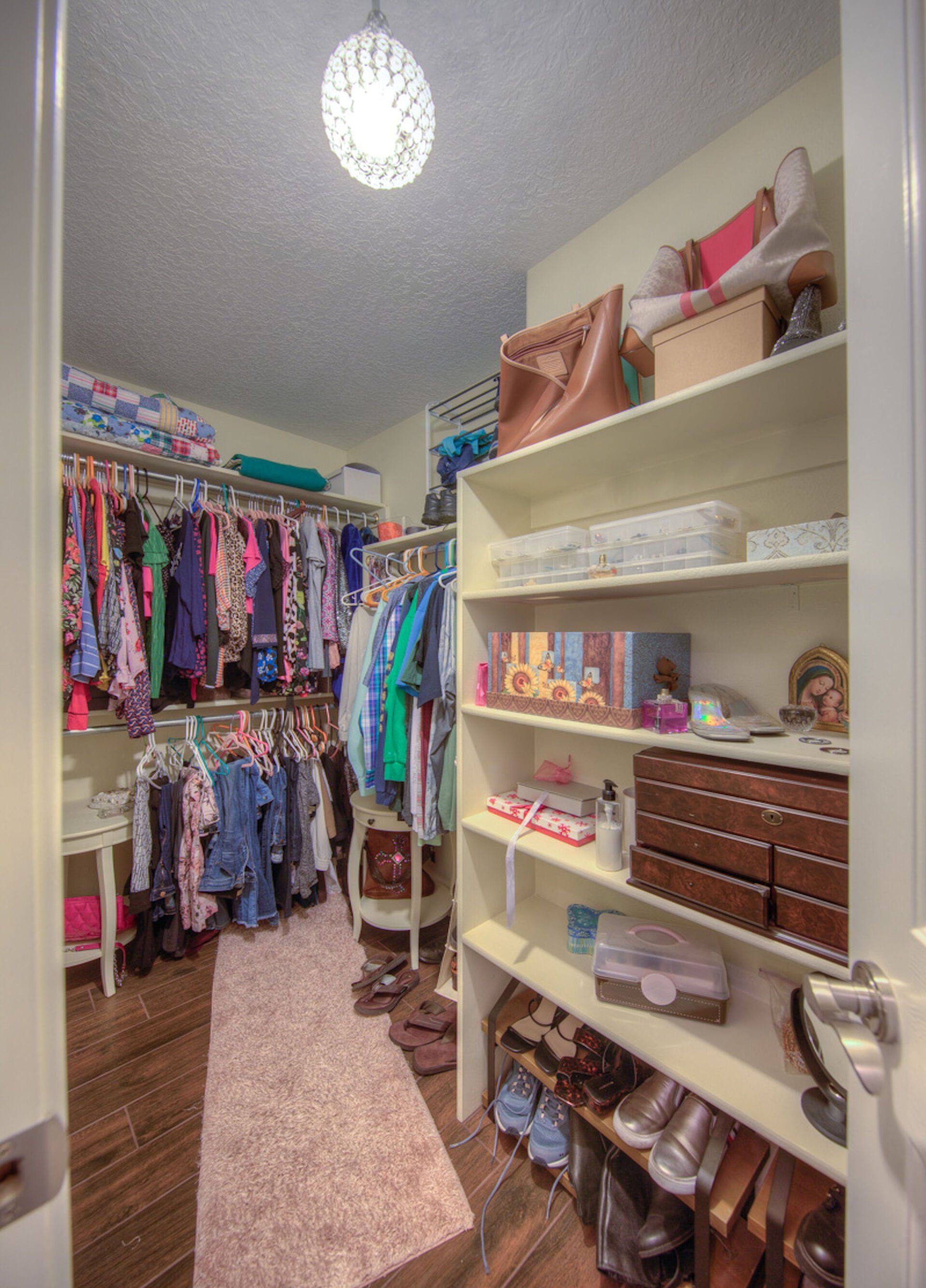 A walk in closet filled with lots of clothes and shoes
