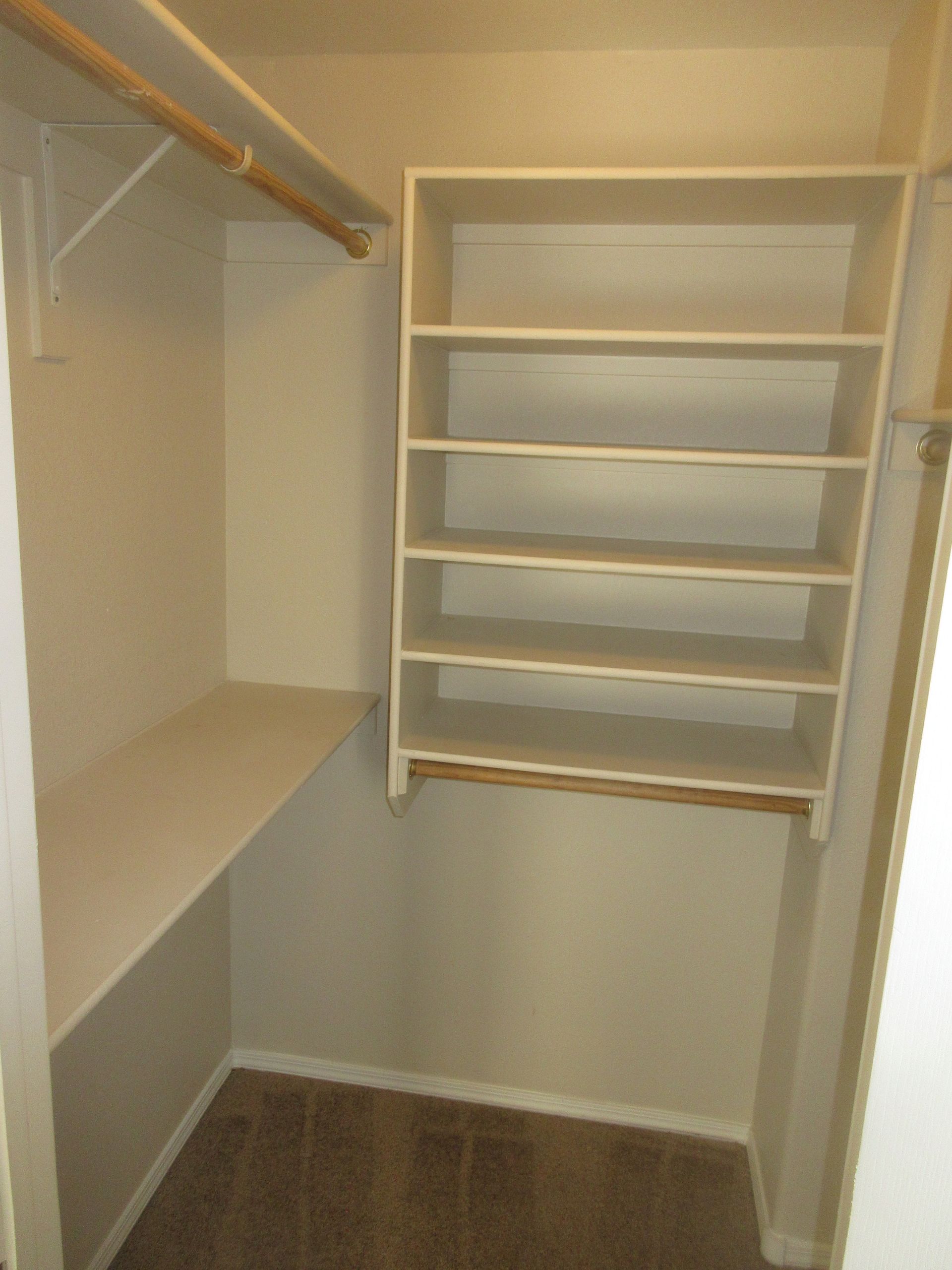 An empty walk in closet with shelves and hanging racks