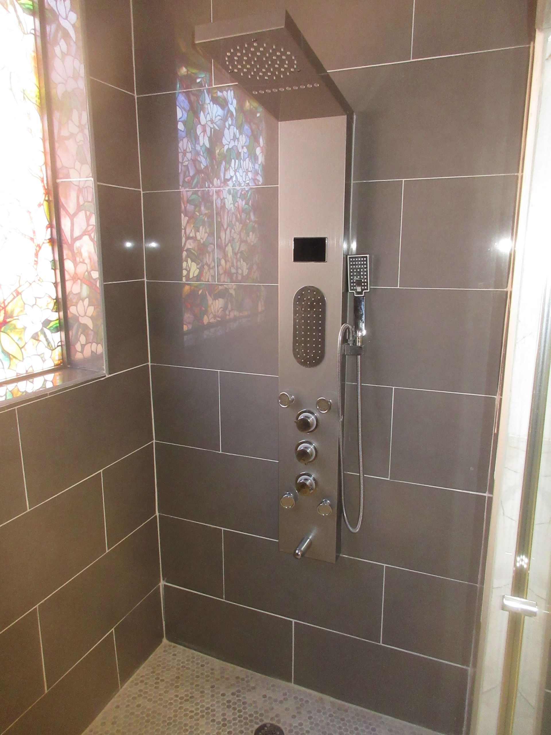 A shower with a stained glass window behind it