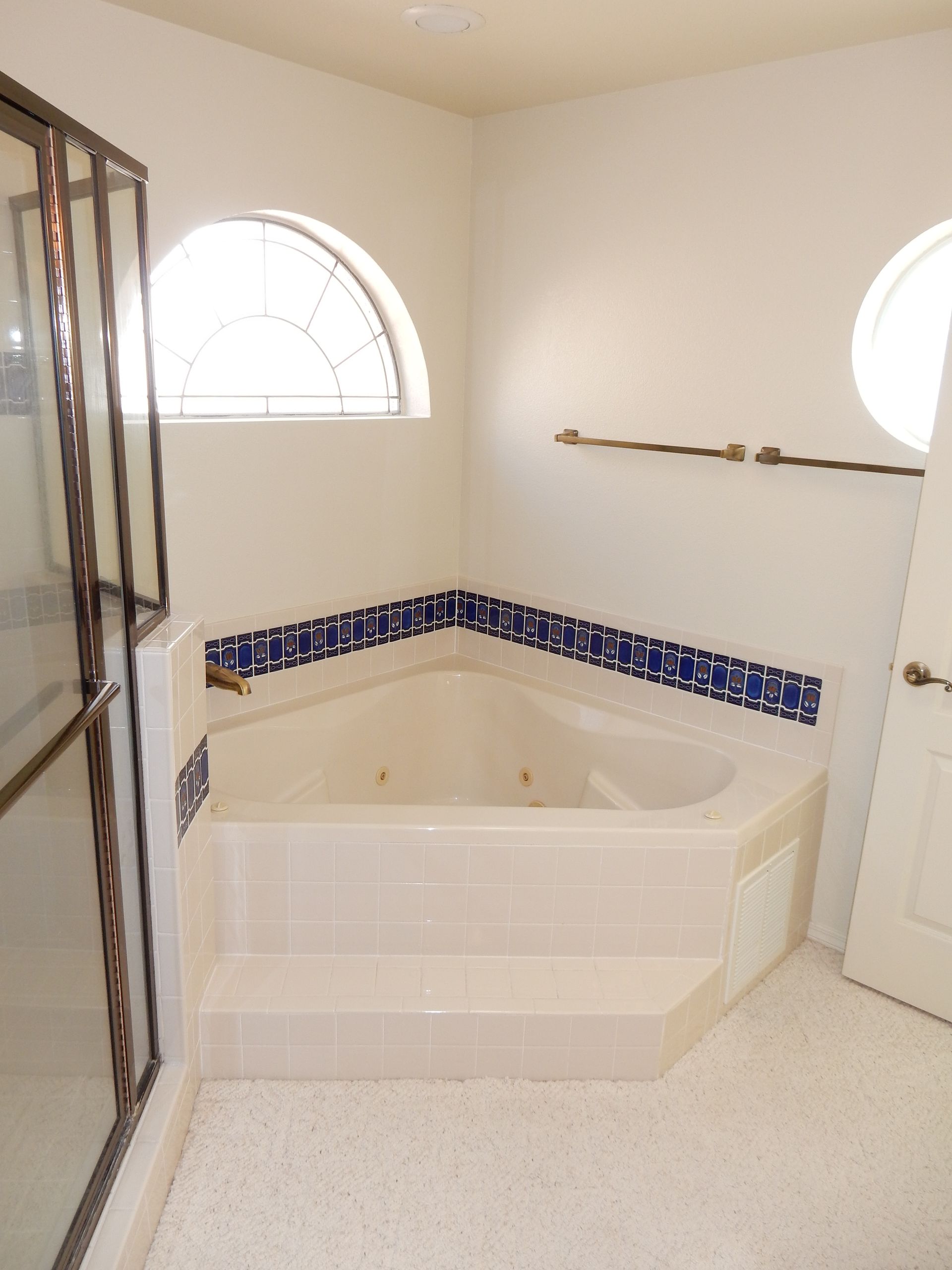 A bathroom with a jacuzzi tub and a window