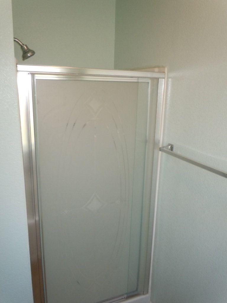 A bathroom with a shower stall and a shower head.