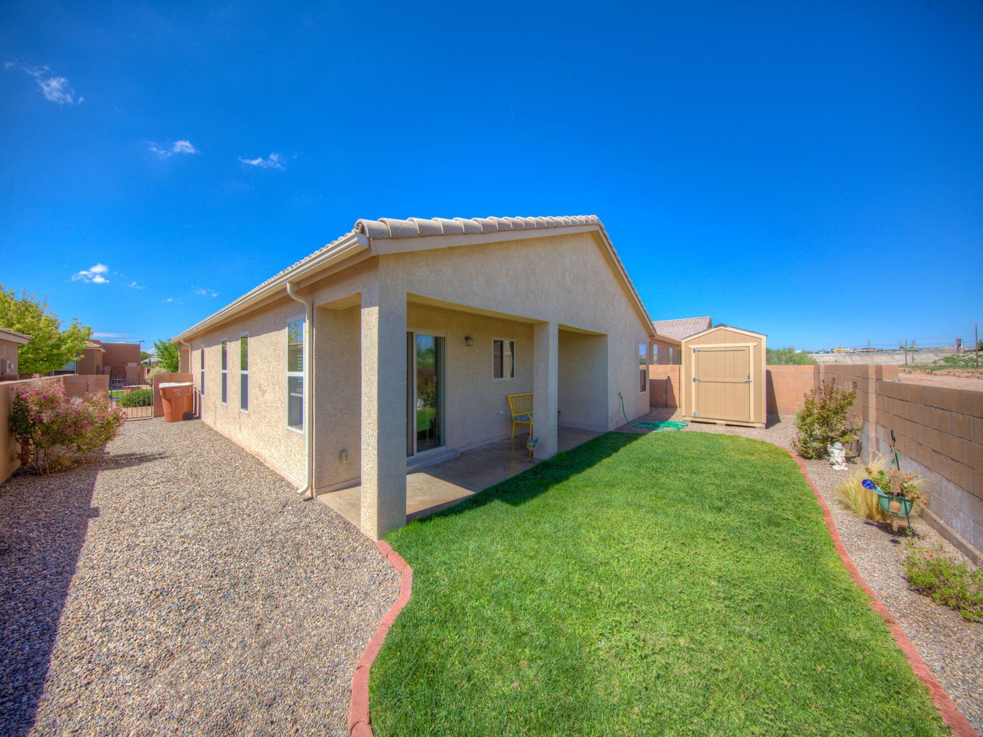 The backyard of a house with a large lawn and a garage.