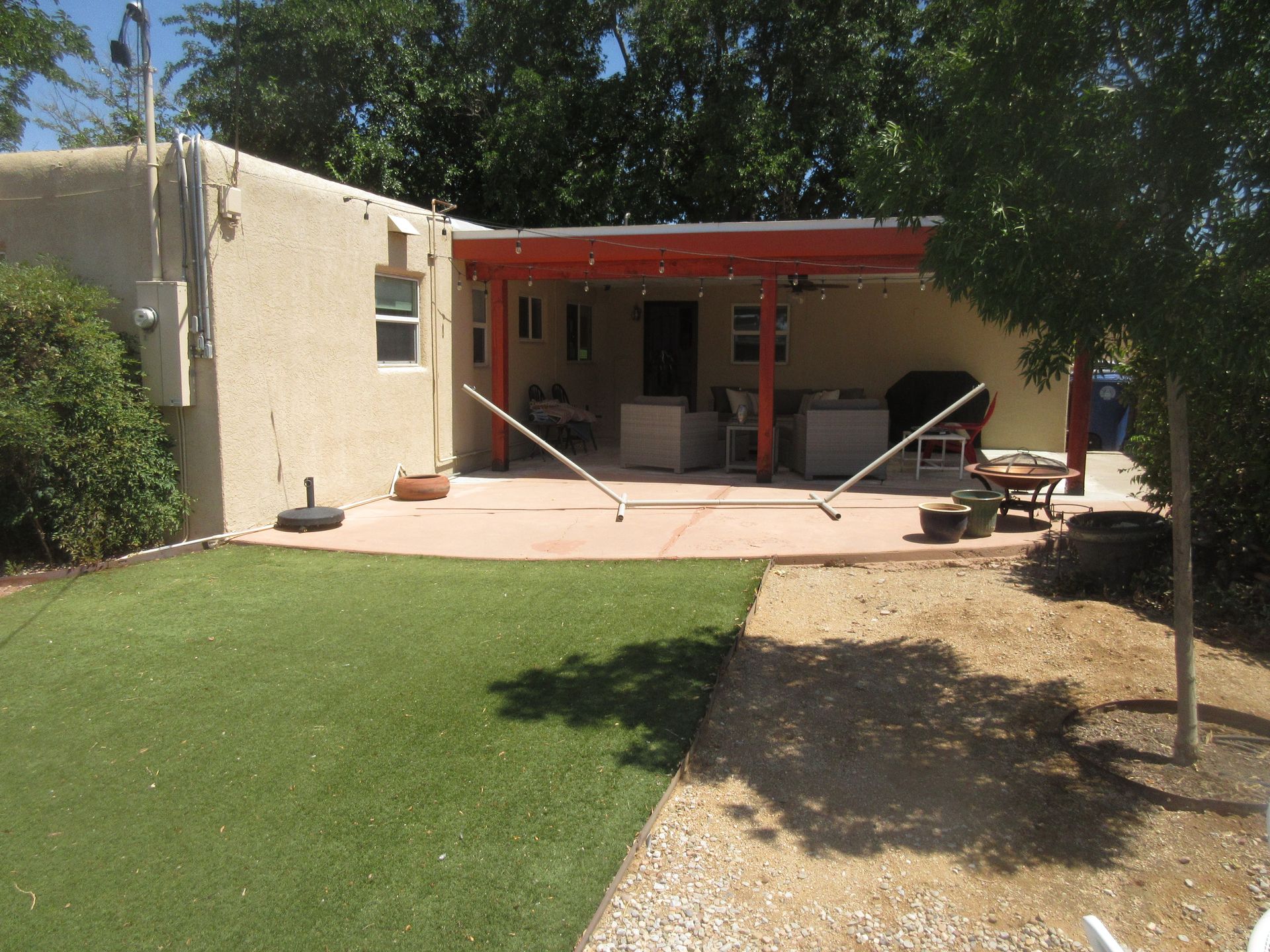 A house with a covered patio and a lawn in front of it