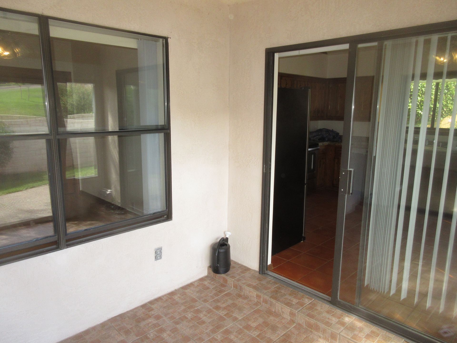 A room with a sliding glass door and two windows