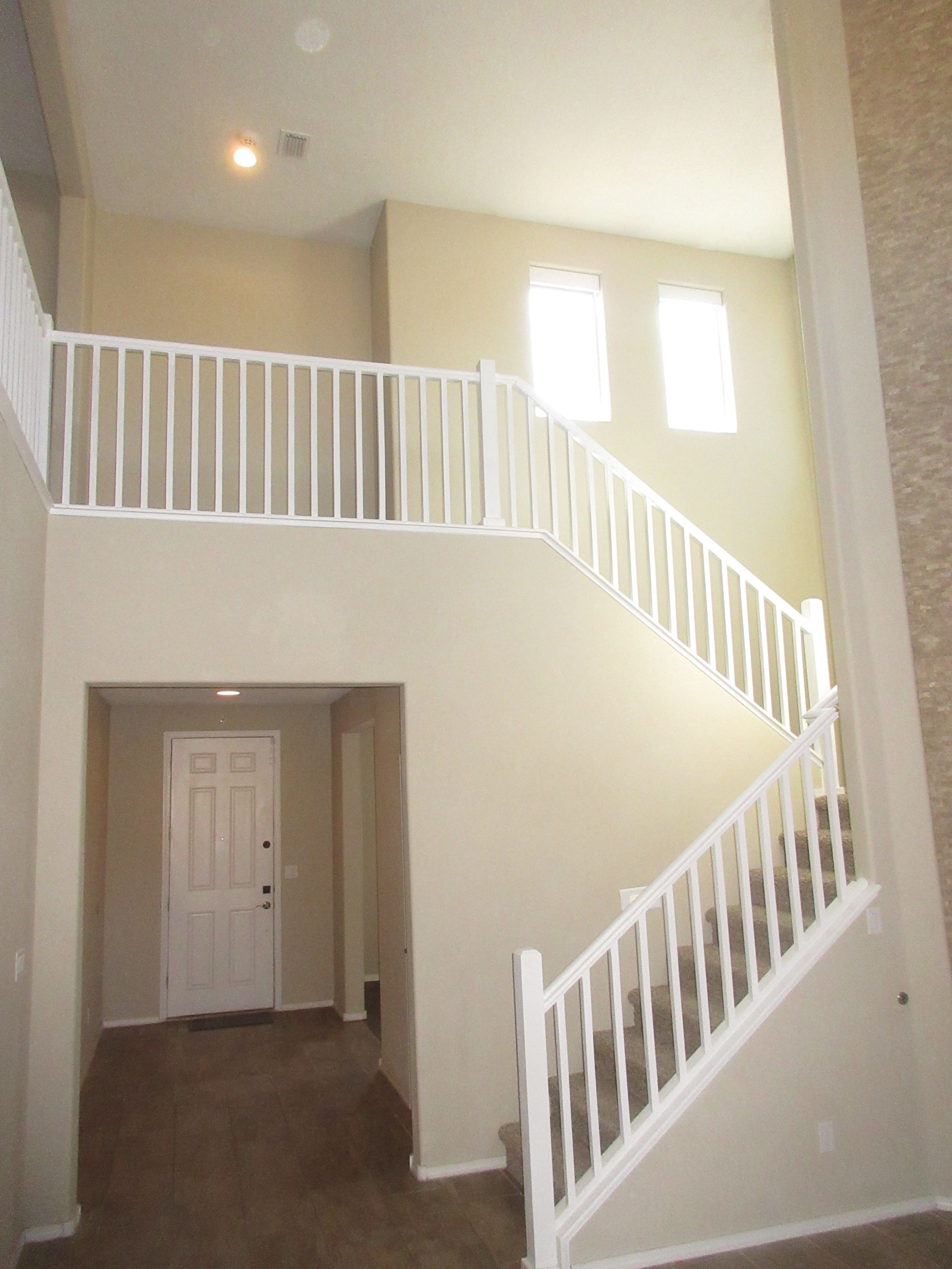 An empty house with a white railing and stairs