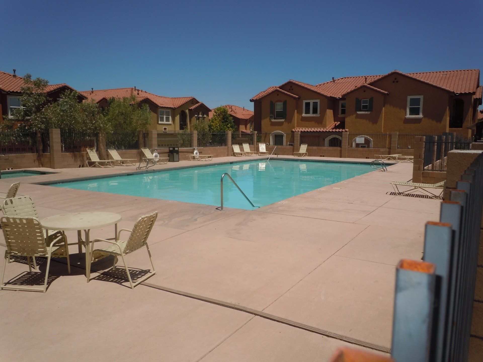 A large swimming pool surrounded by chairs and tables
