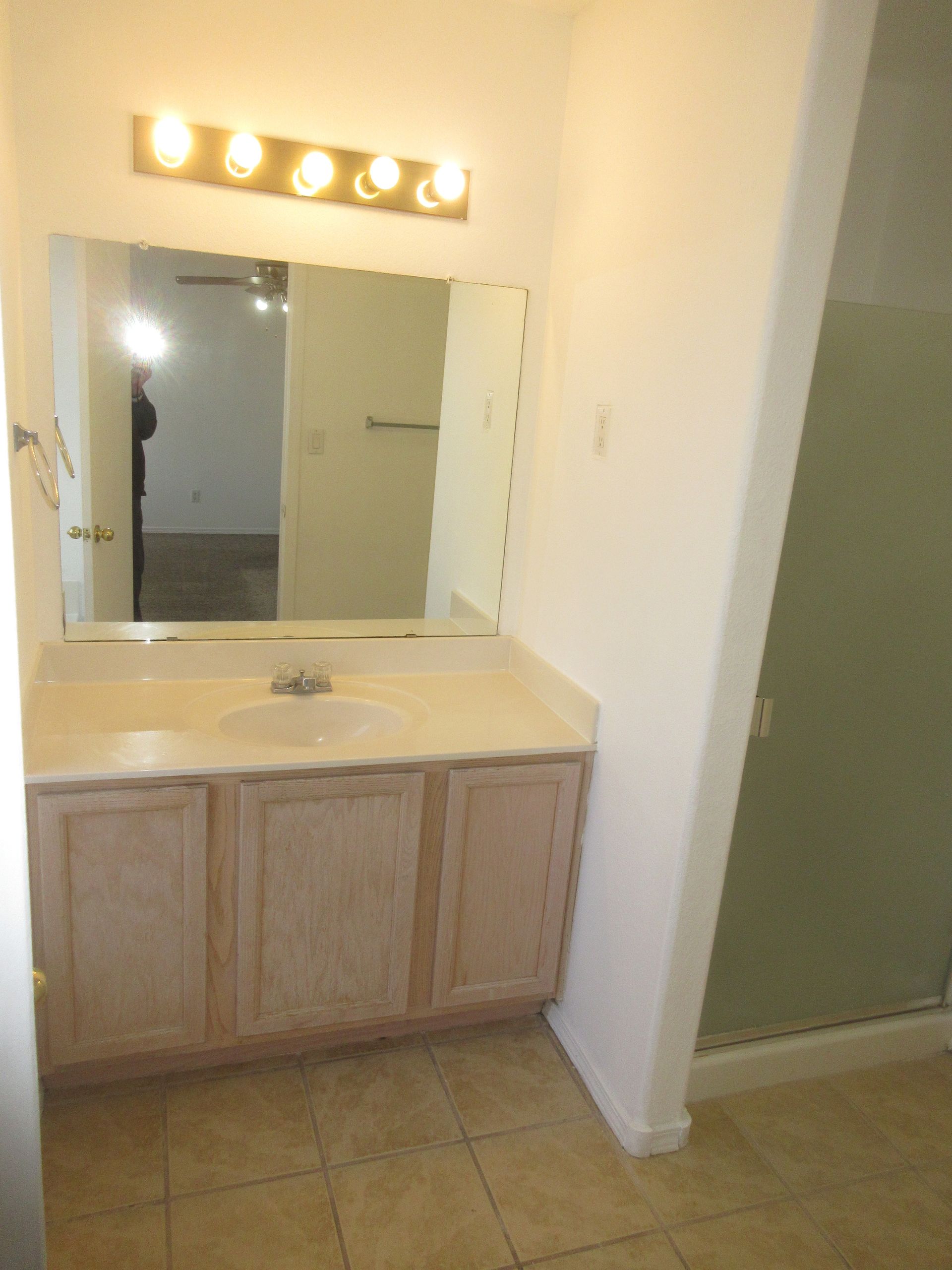 A bathroom with a sink and a large mirror