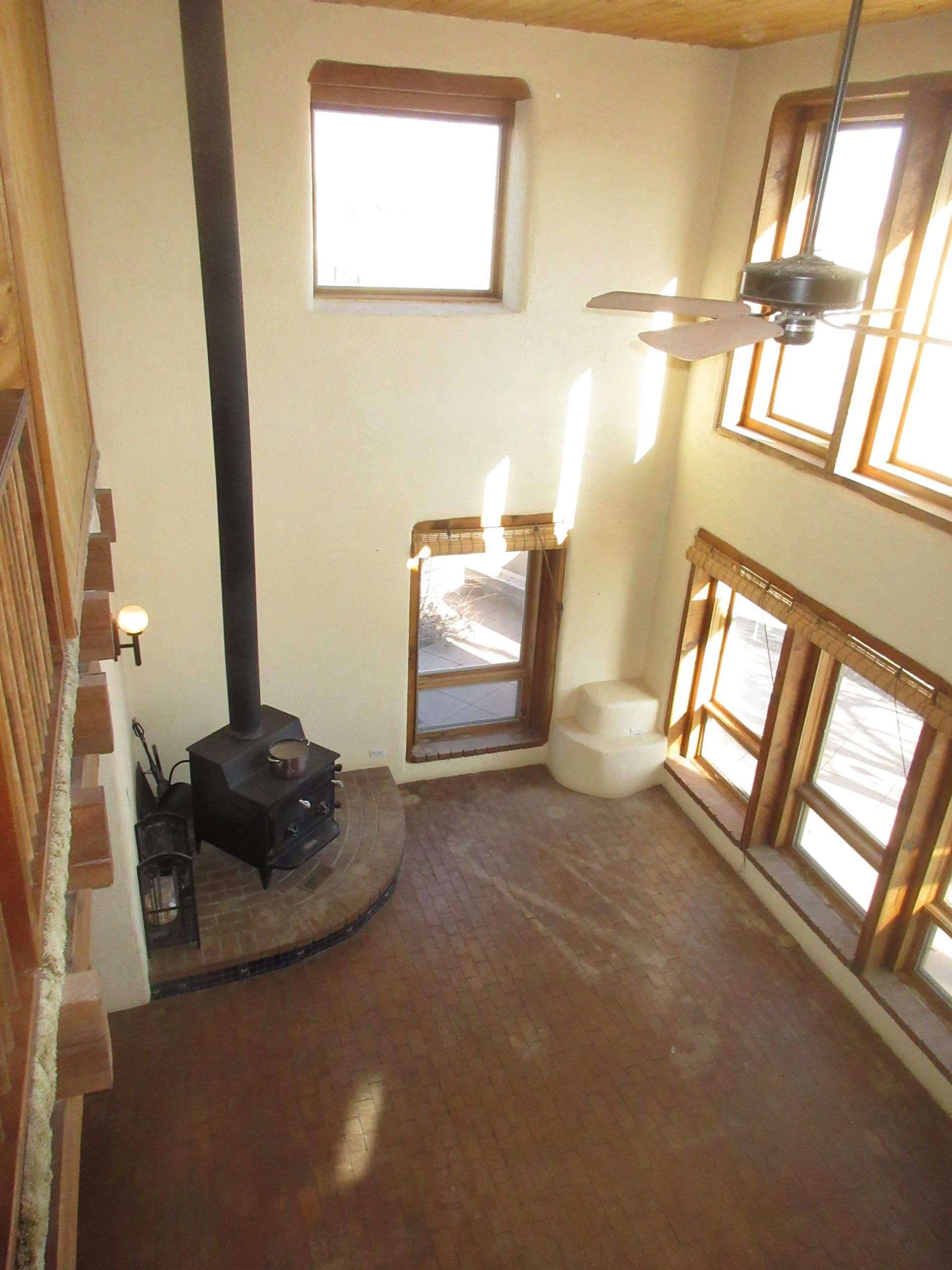 A living room with a ceiling fan and a wood stove