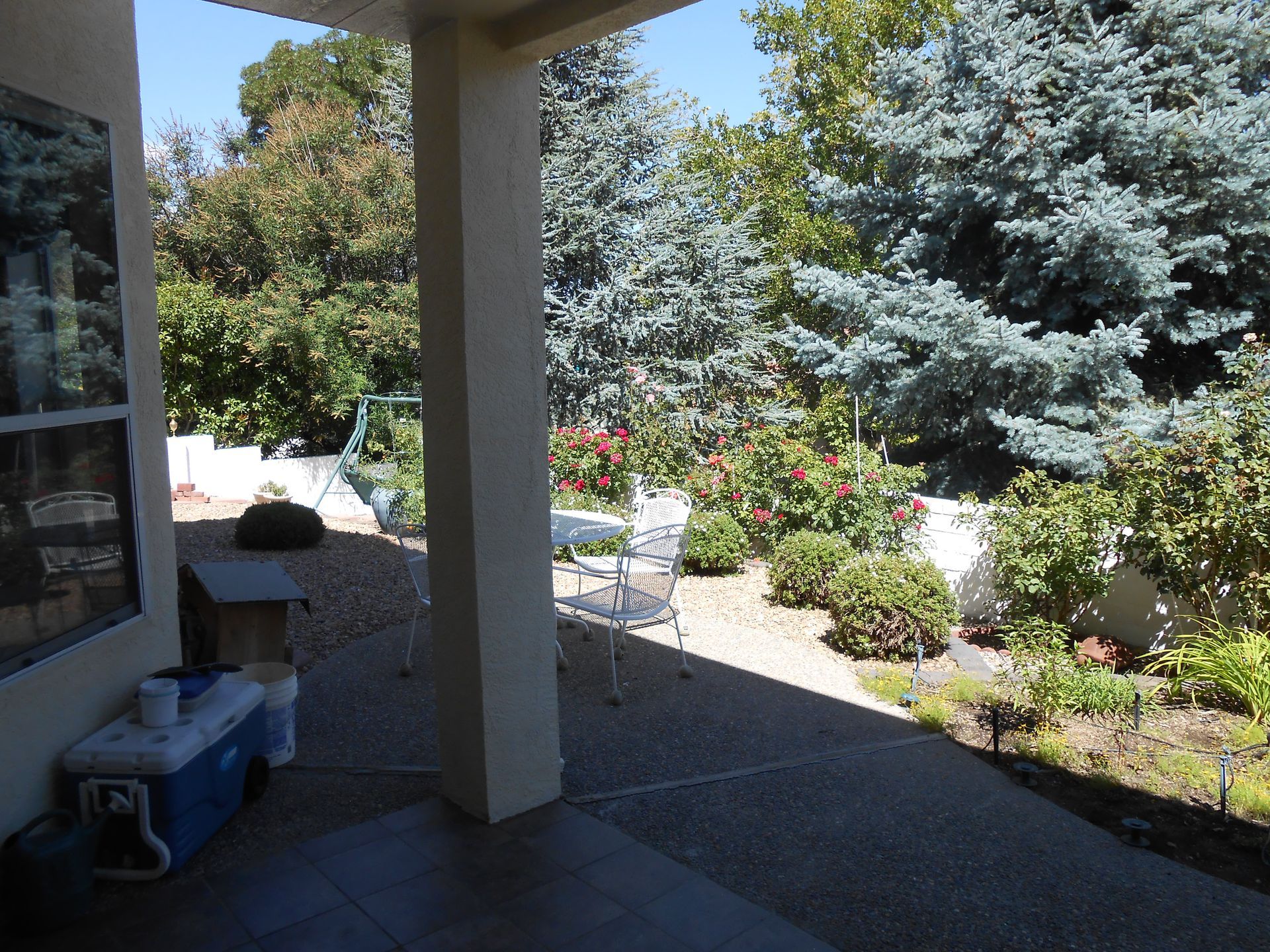 A blue cooler sits on the patio of a house