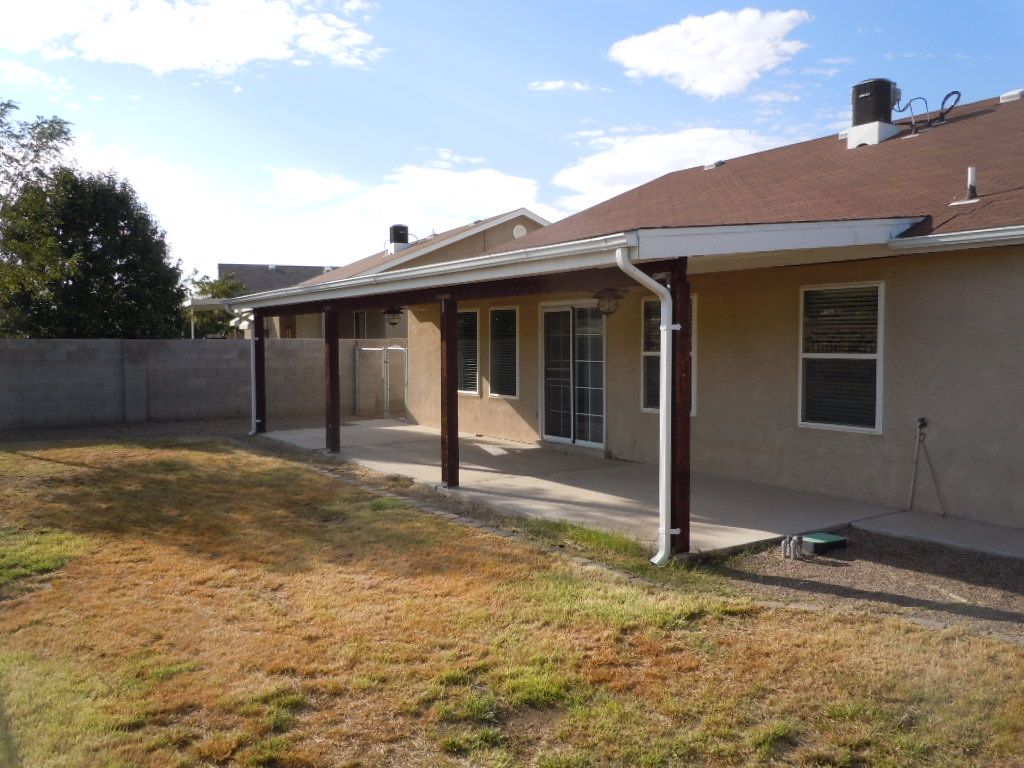 The backyard of a house with a covered patio