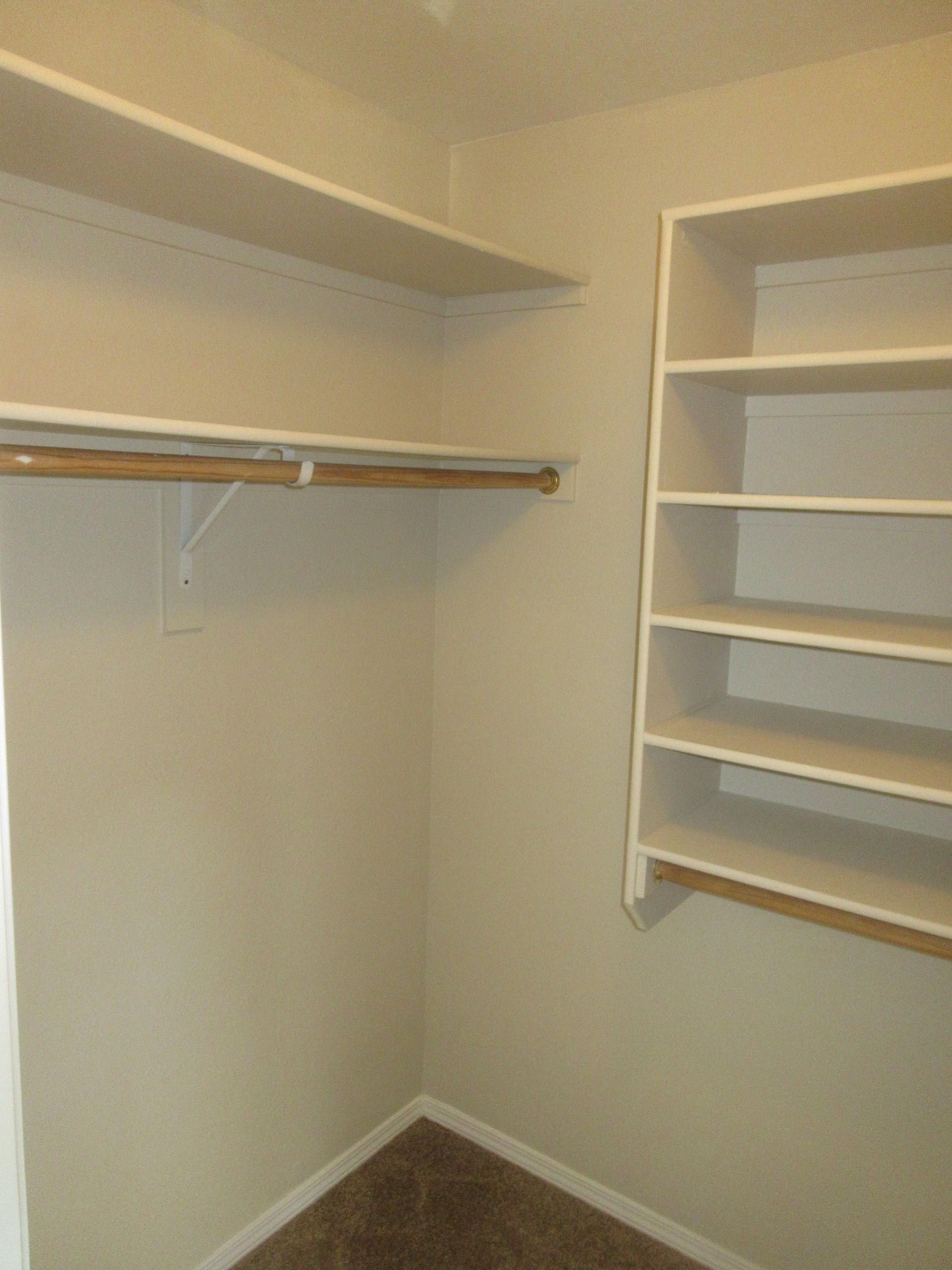 An empty walk in closet with shelves and clothes racks