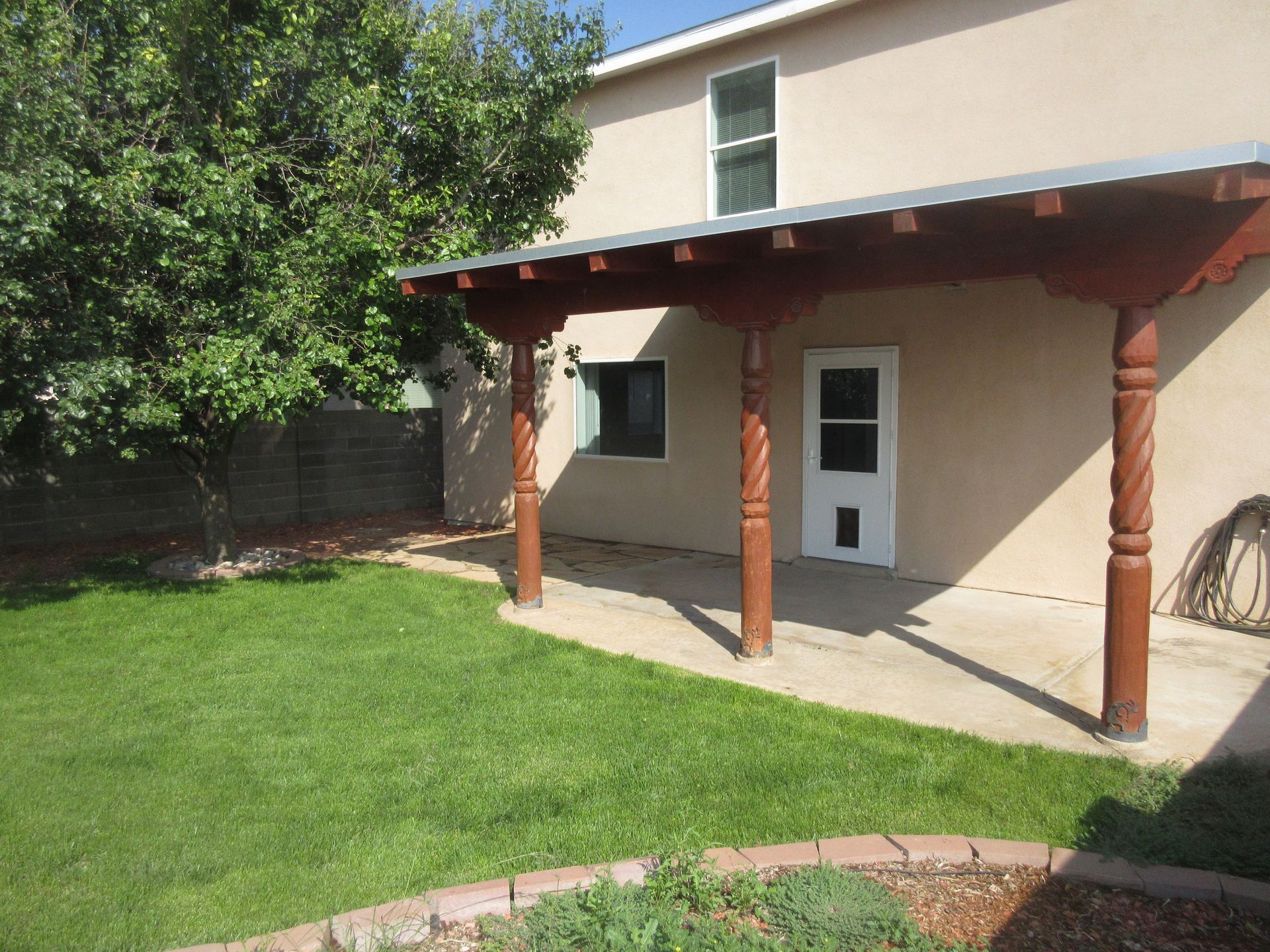 A house with a covered patio and a dog door