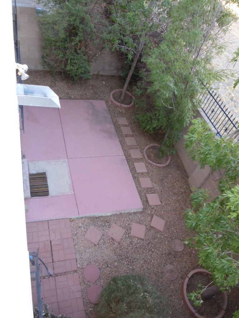 An aerial view of a backyard with bricks and trees