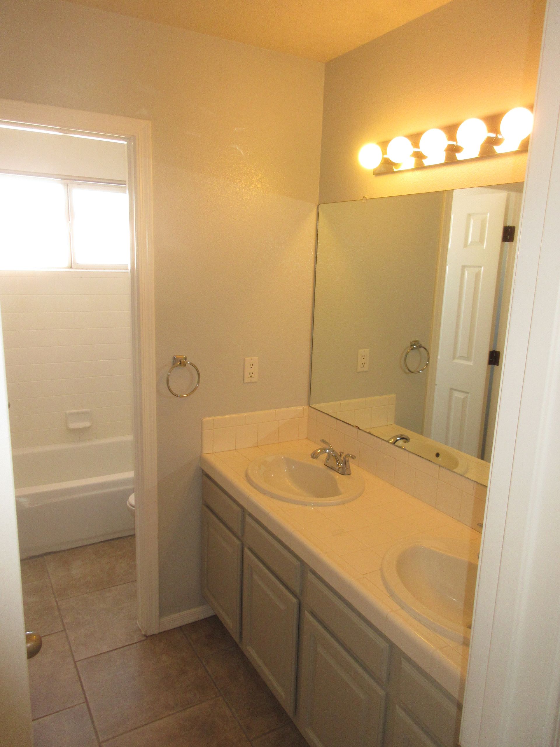A bathroom with two sinks and a mirror