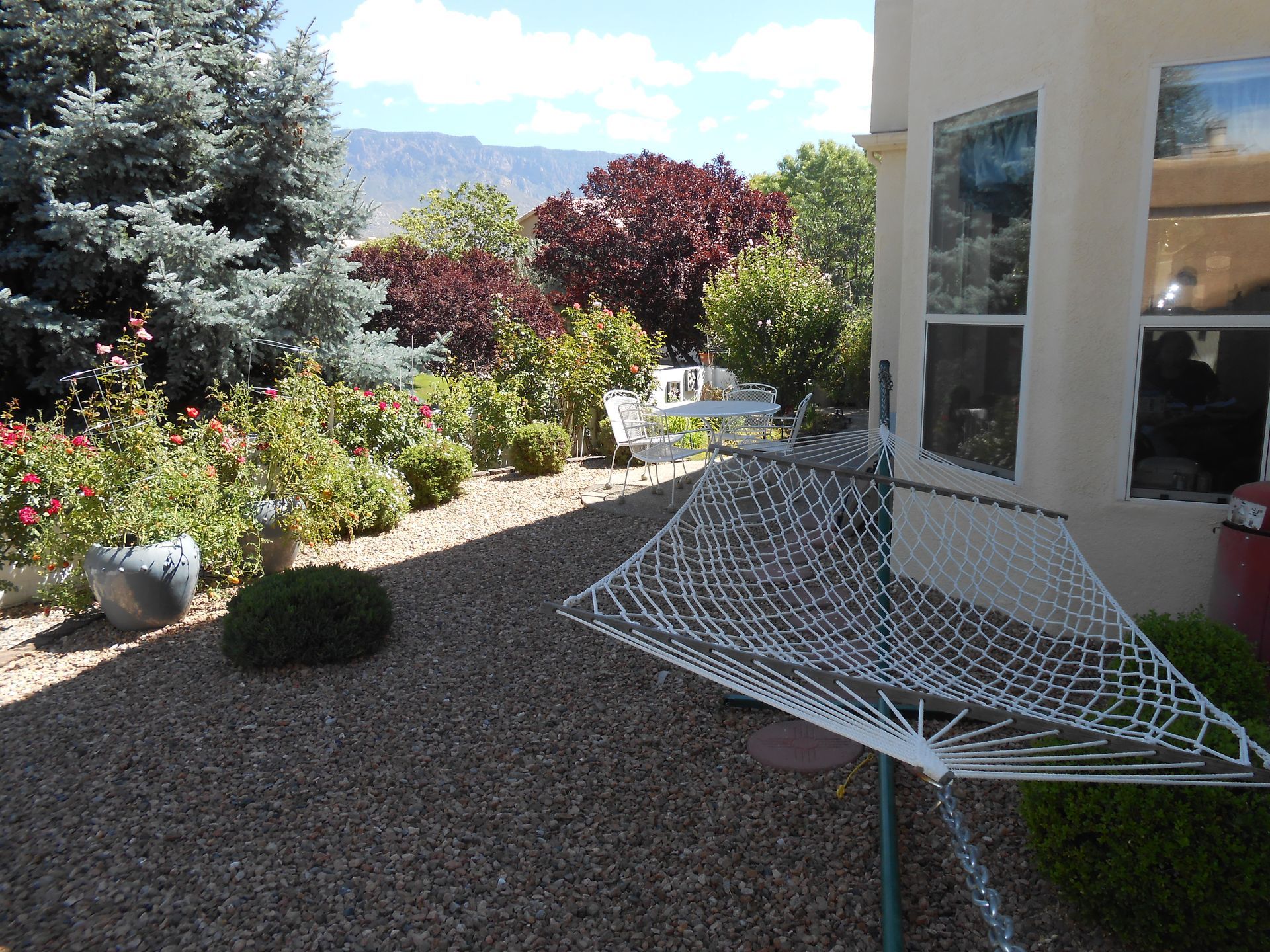 A white hammock is sitting in front of a house