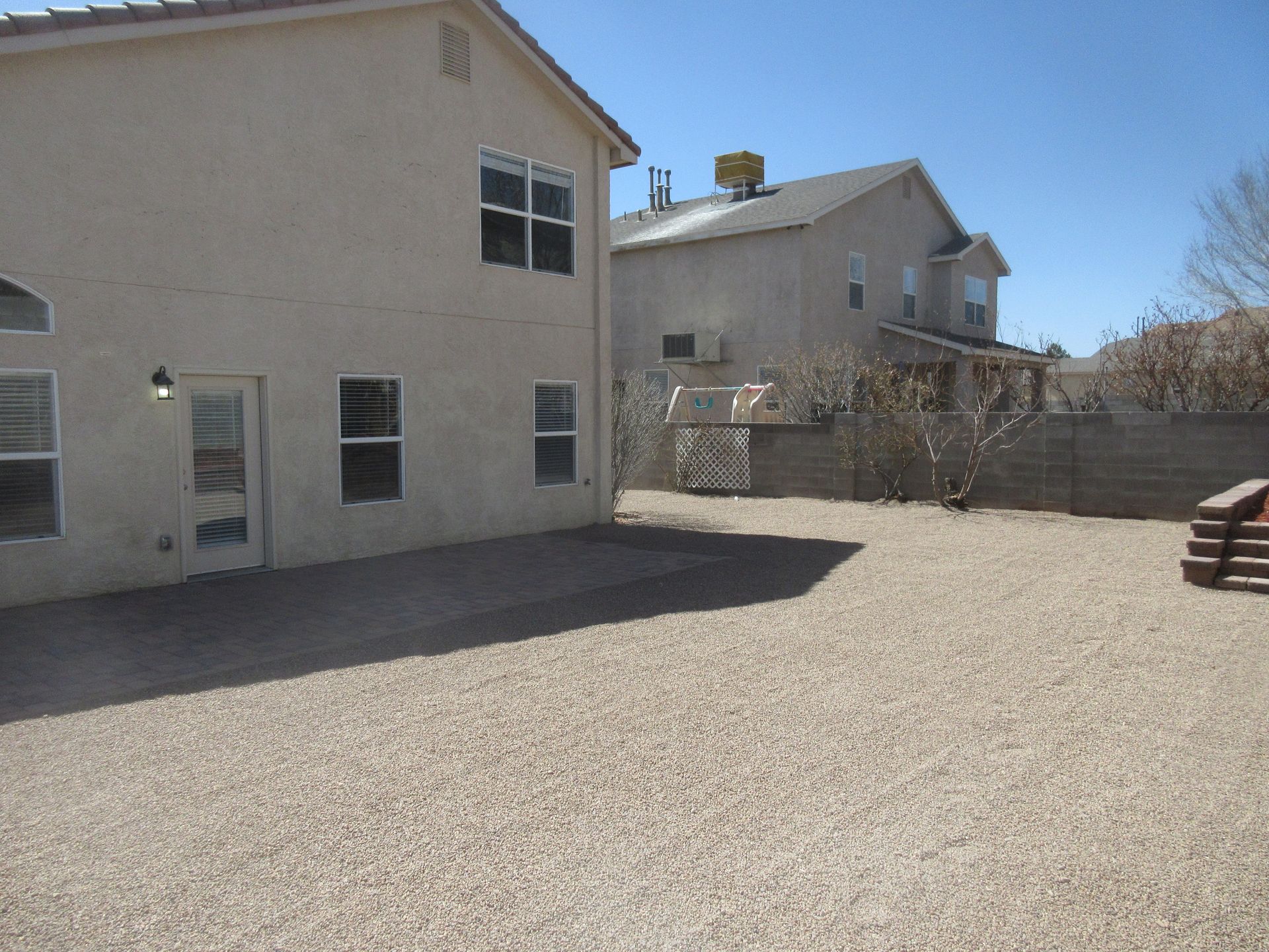 A house with a lot of windows and a gravel driveway