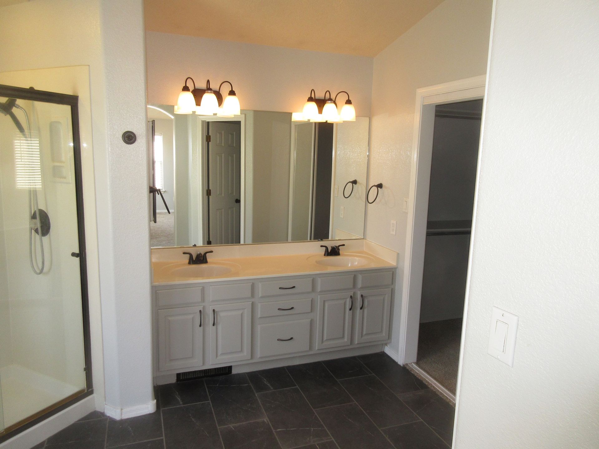 A bathroom with two sinks and a walk in shower