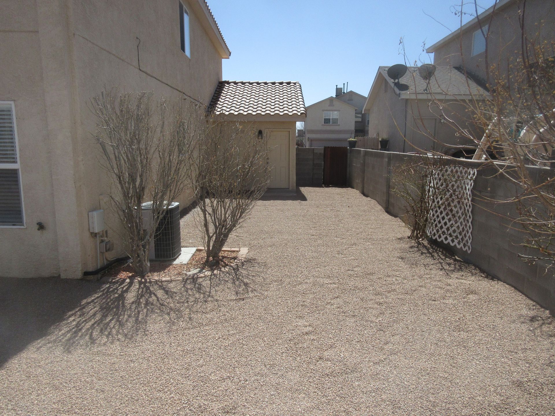 A gravel driveway leading to a house with a garage