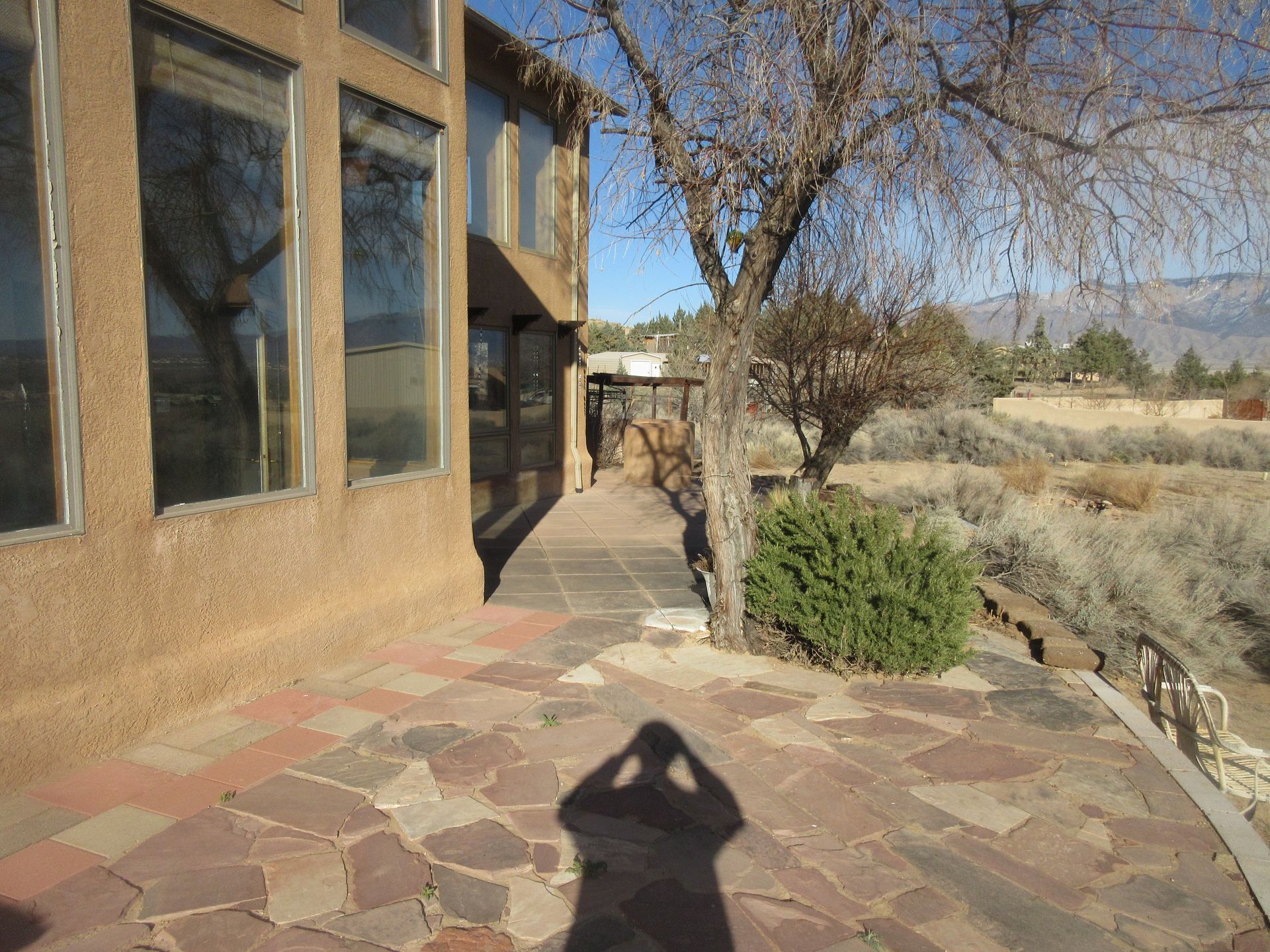 A shadow of a person is cast on a stone walkway