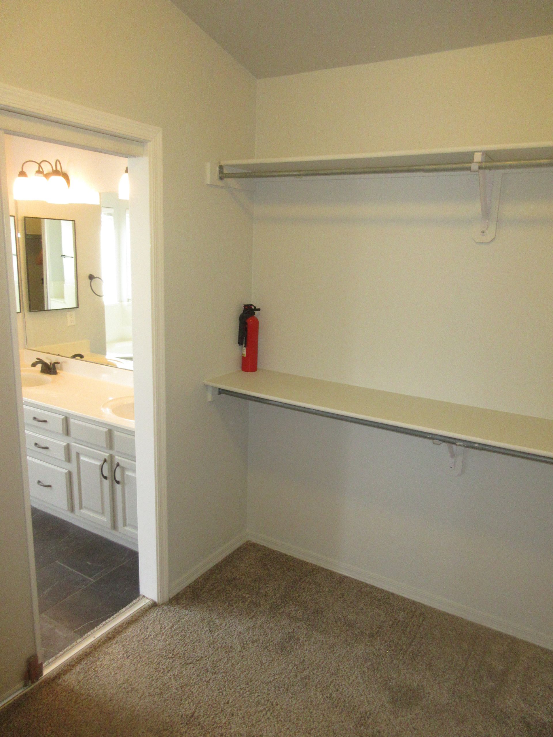 There is a fire extinguisher on the shelf in the closet.