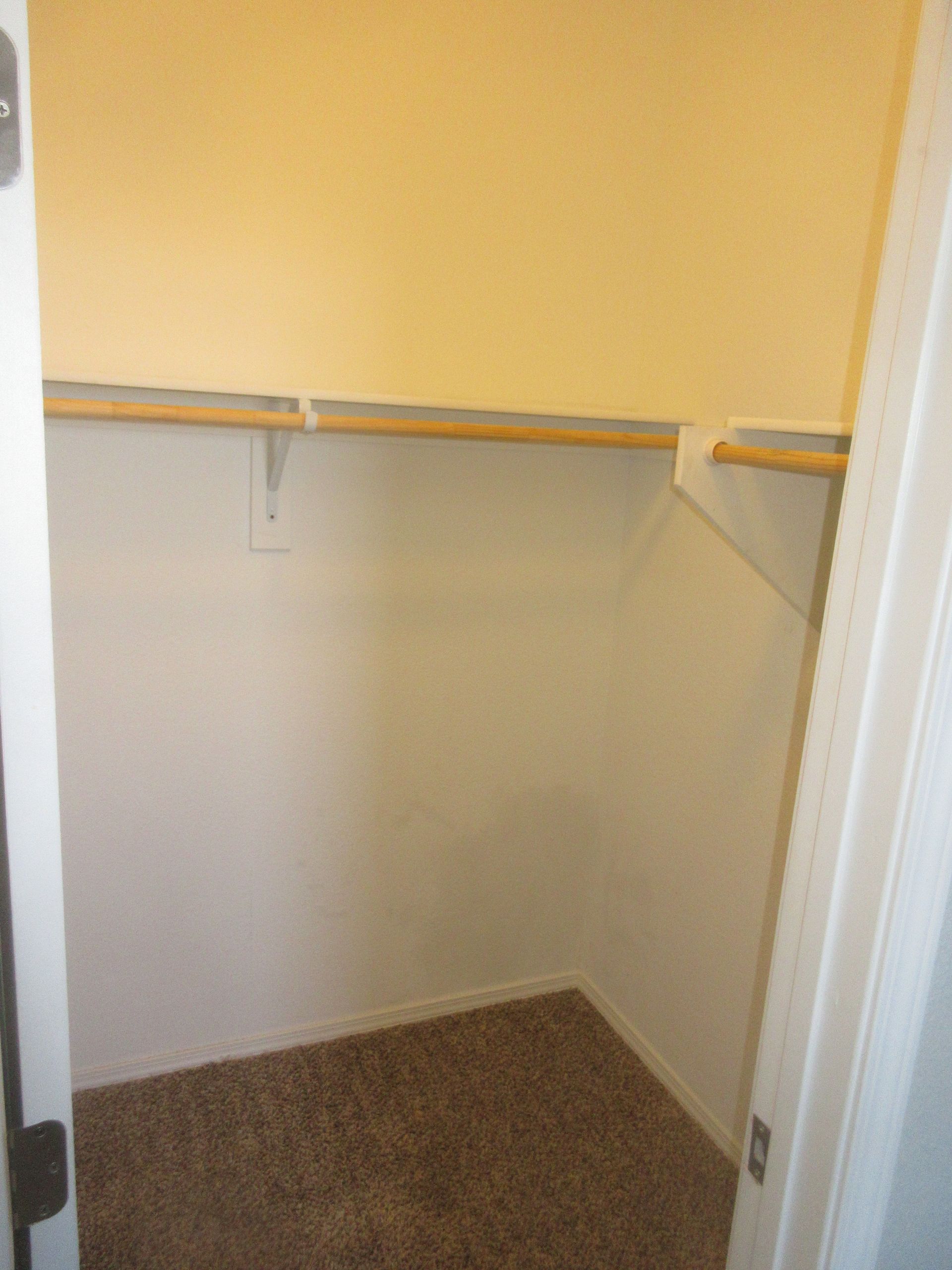 An empty closet with a shelf and a door