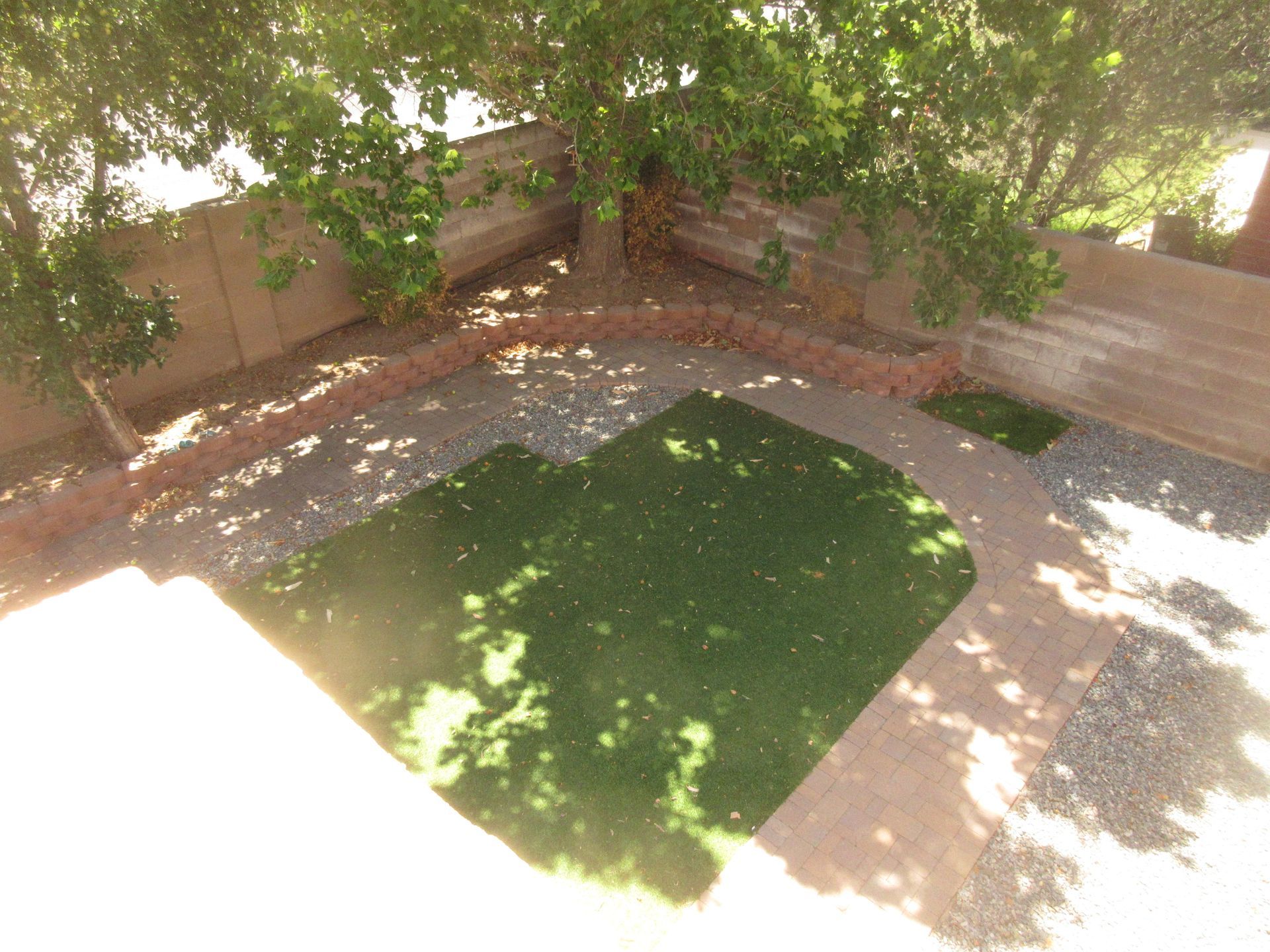 An aerial view of a backyard with grass and trees