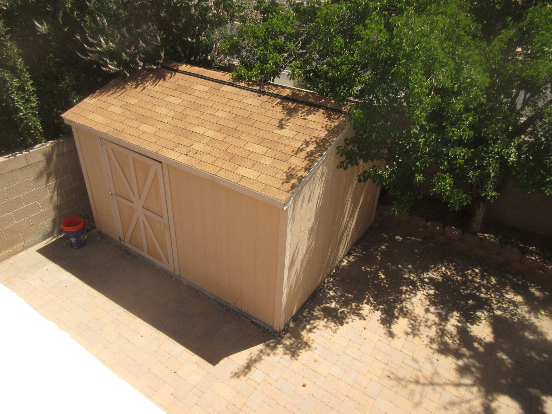 An aerial view of a shed in a backyard surrounded by trees