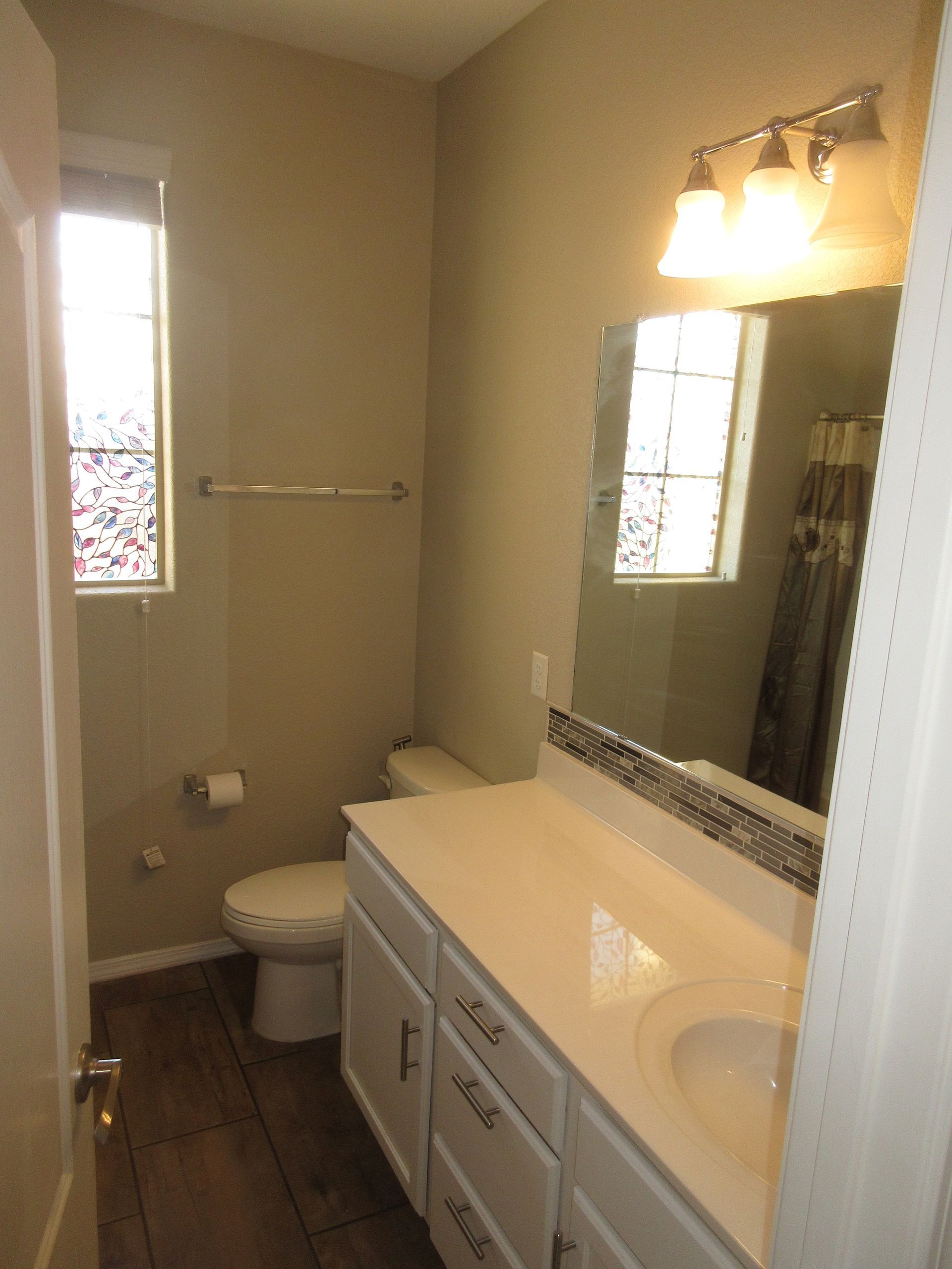 A bathroom with a toilet a sink and a mirror