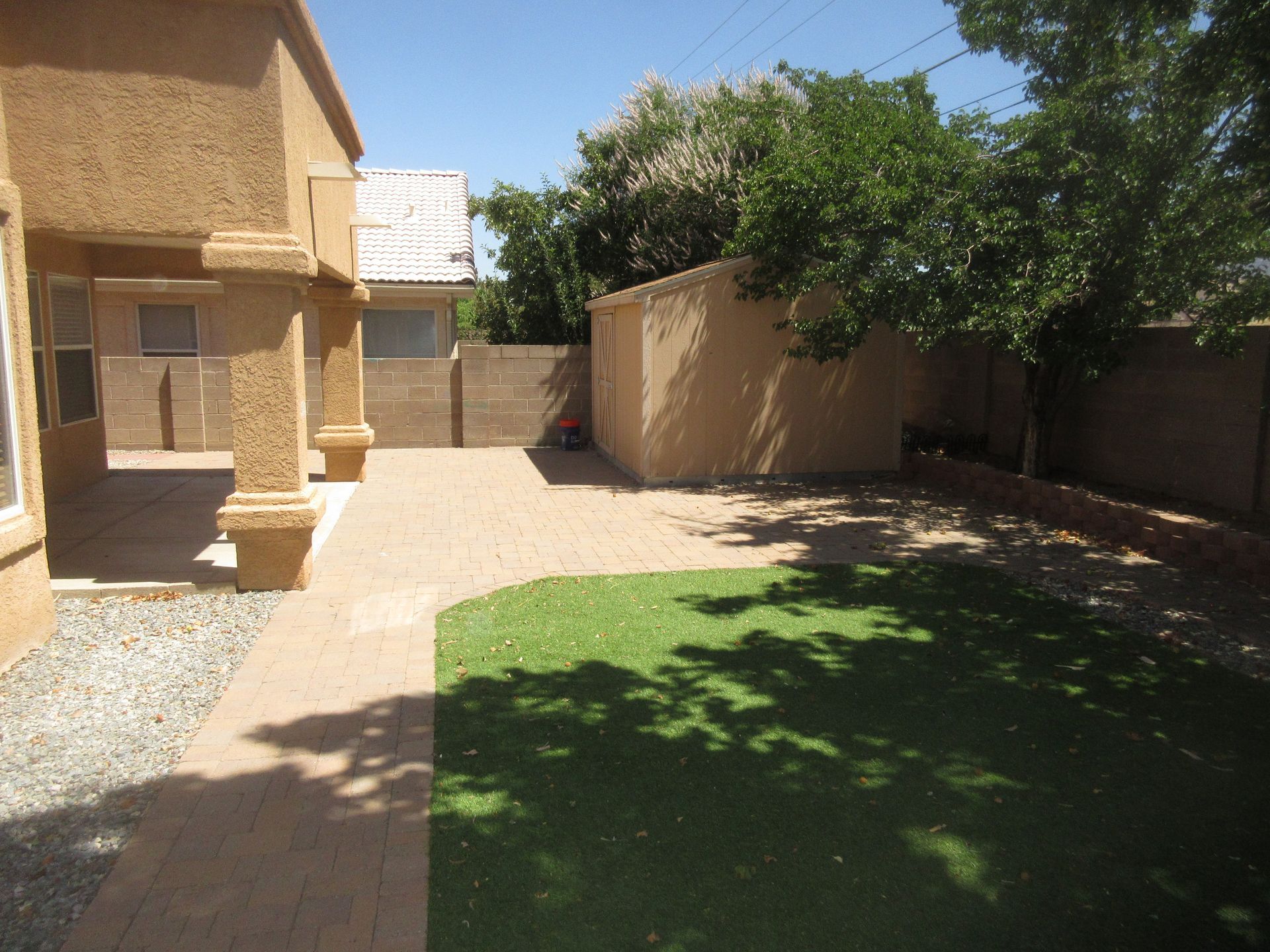 The backyard of a house with a patio and a shed