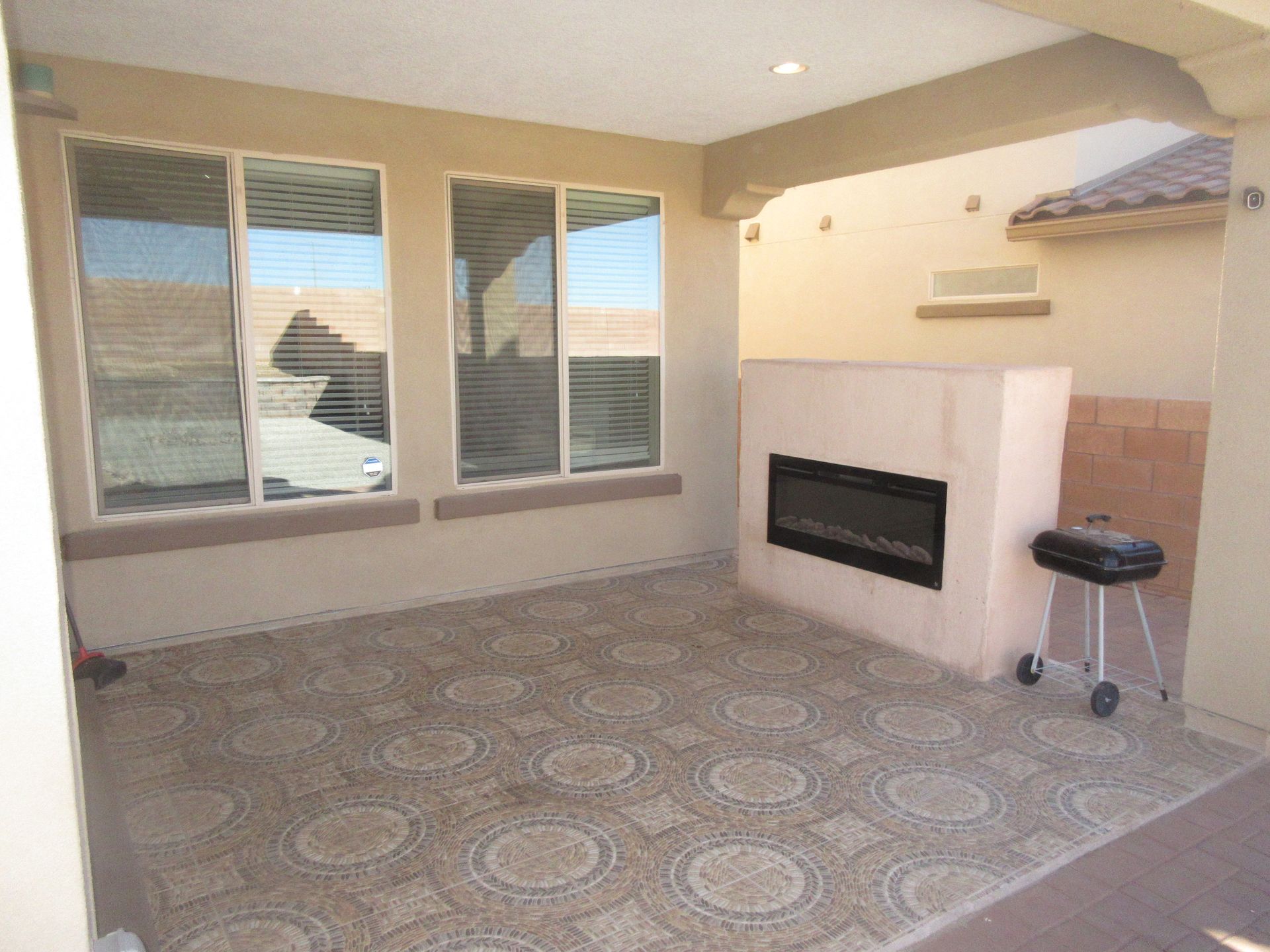 A patio with a fireplace and a grill