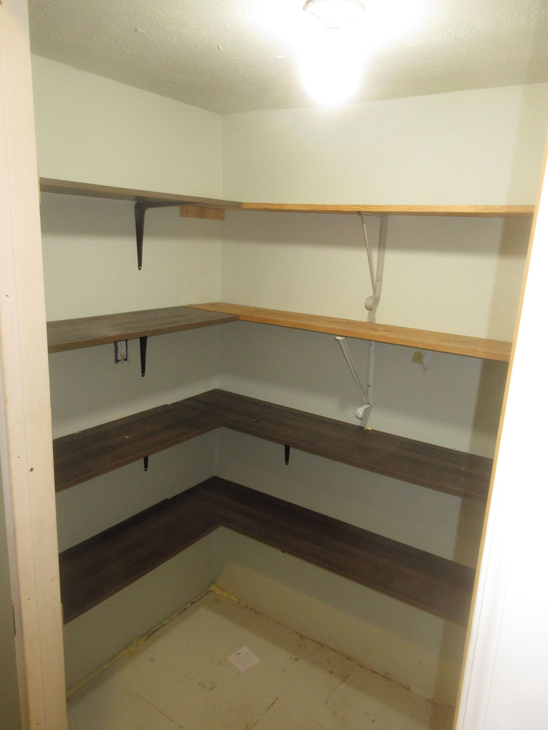 A closet with shelves and a light on the ceiling