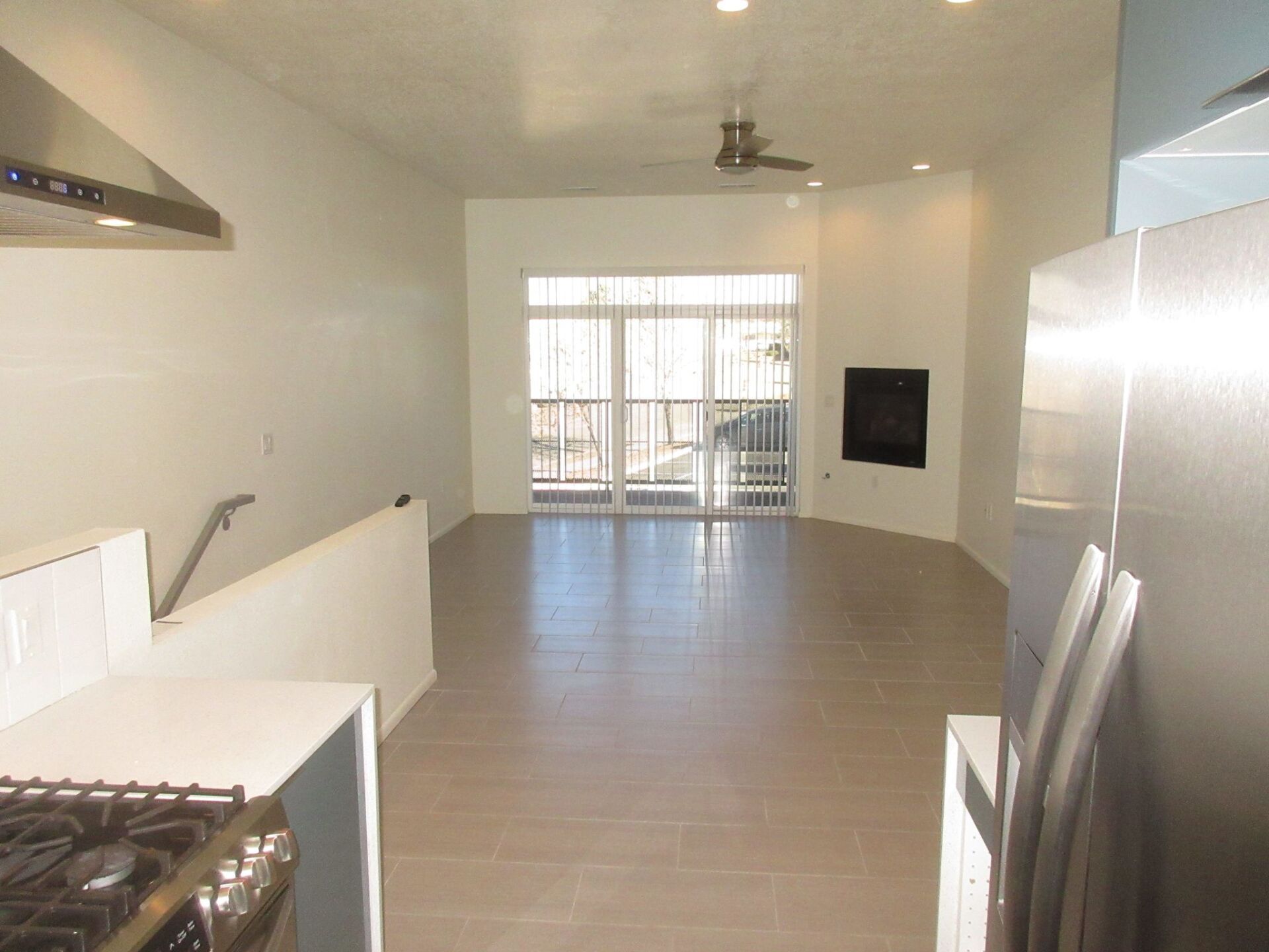 An empty kitchen with a stove and a refrigerator