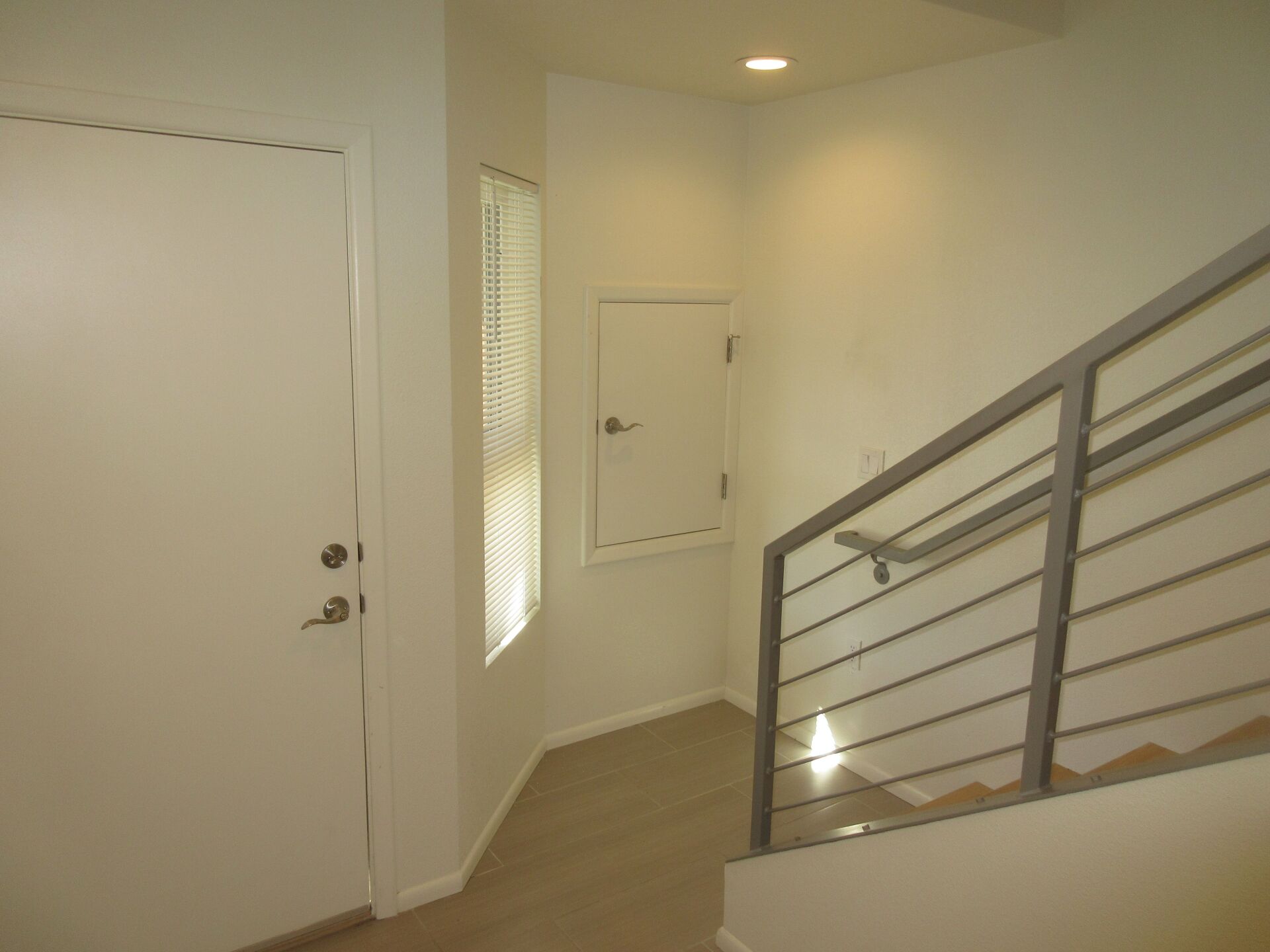 An empty hallway with stairs and a door
