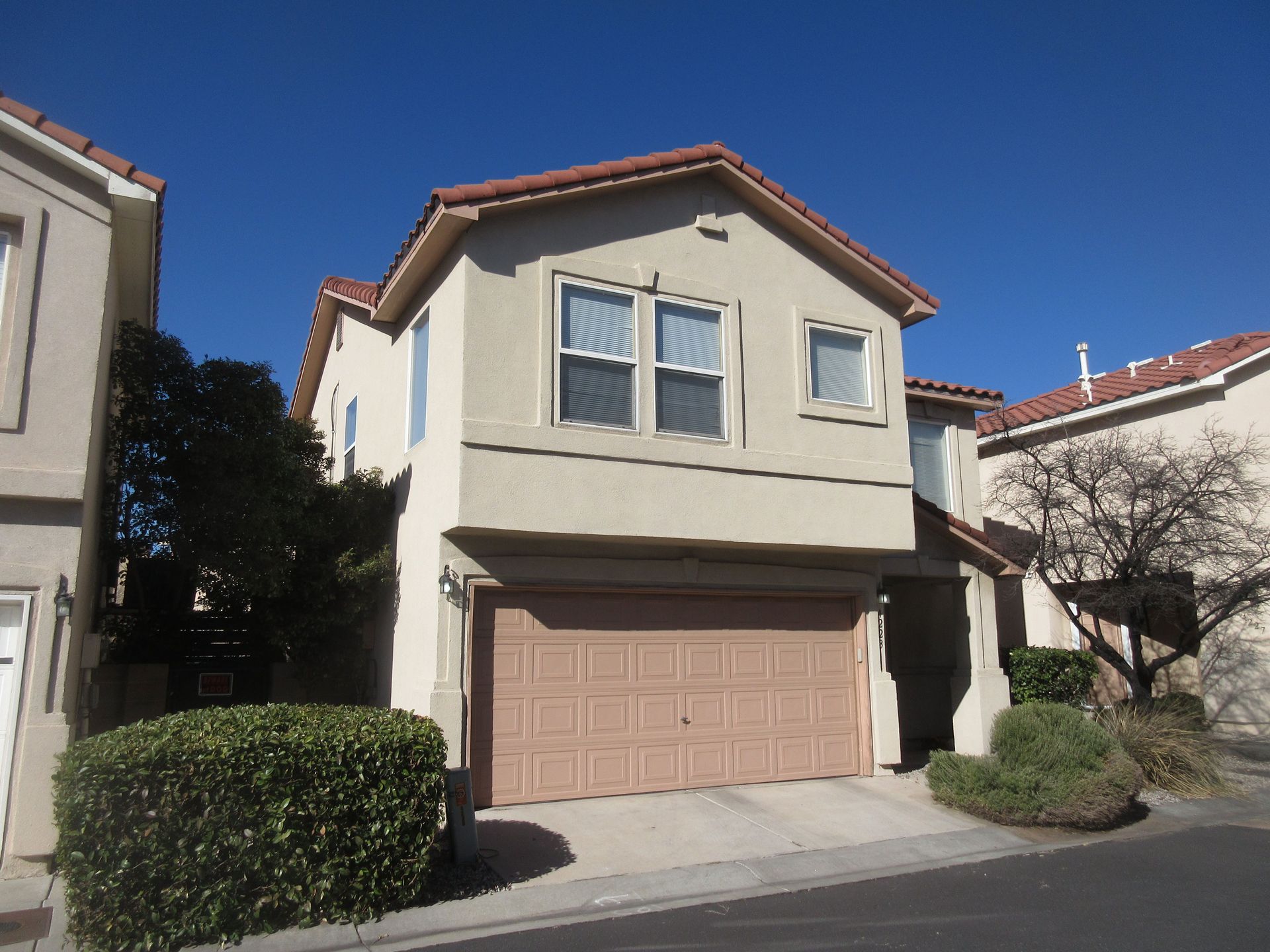 A house with a garage and a blue sky in the background